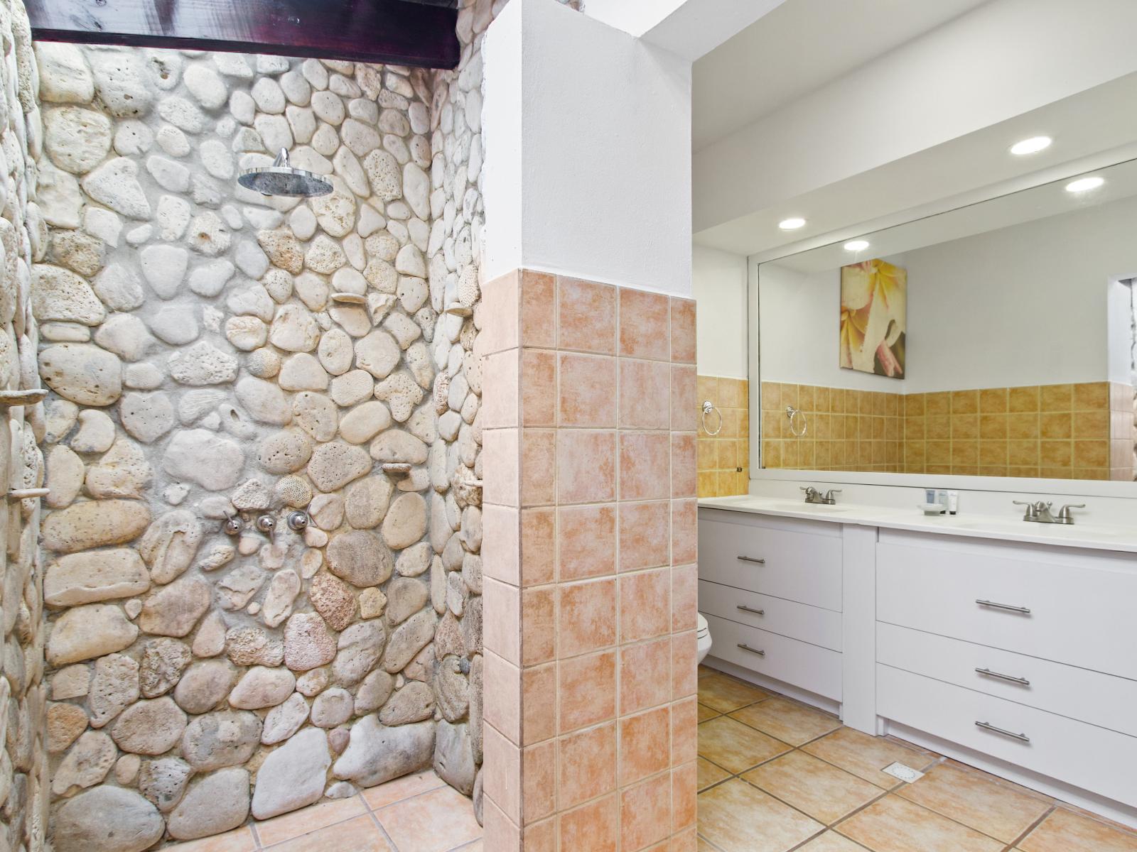 Lavish Bathroom of the villa in Oranjestad Aruba - Neat and clean toilet seat - Availability of all bathroom amenities - Beautiful large vanity with large size mirror and twin sinks - Elegant lighting - Stunning separate shower area