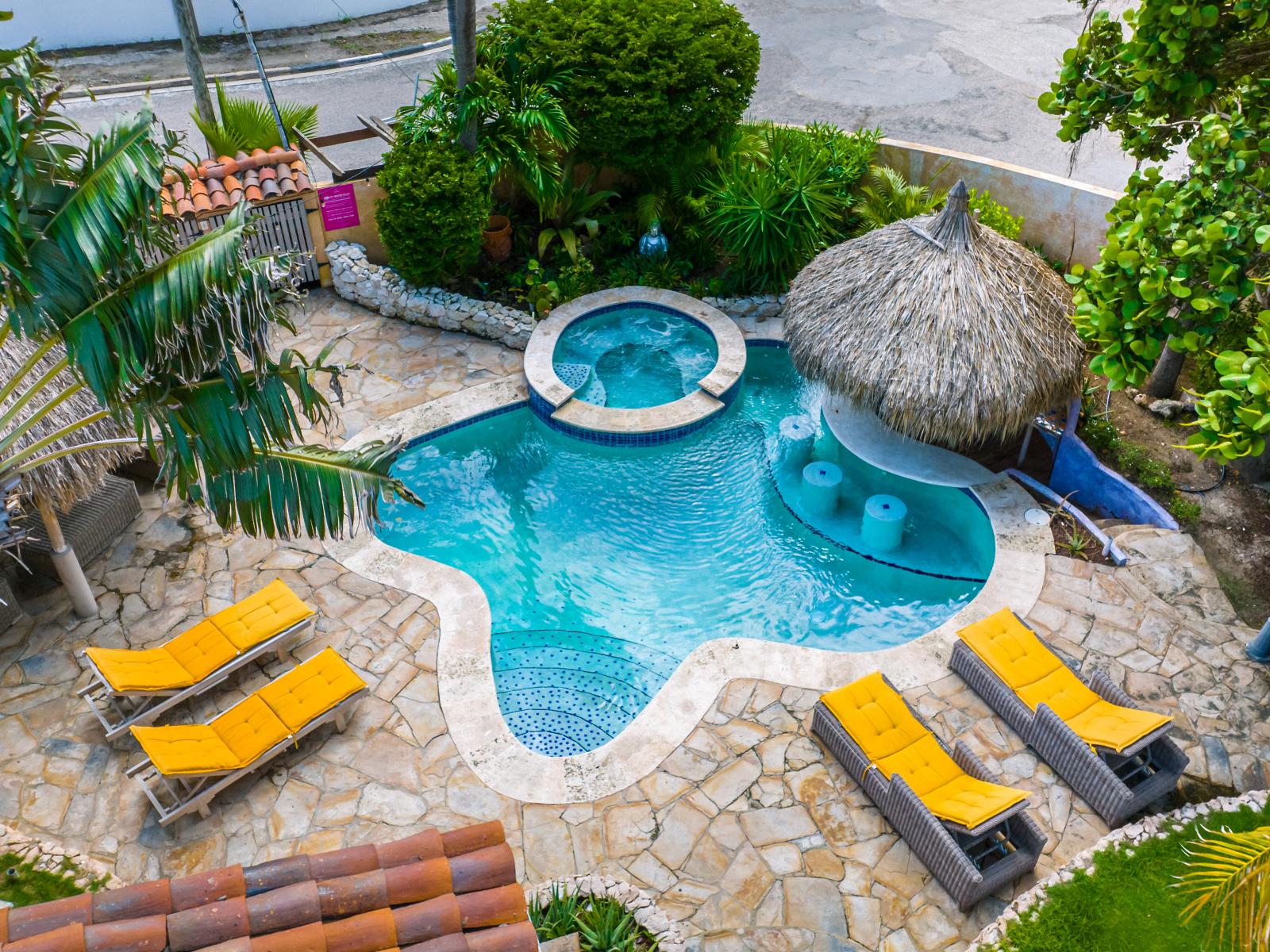 Indulge in serenity at our private tropical pool and hot tub, surrounded by lush greenery