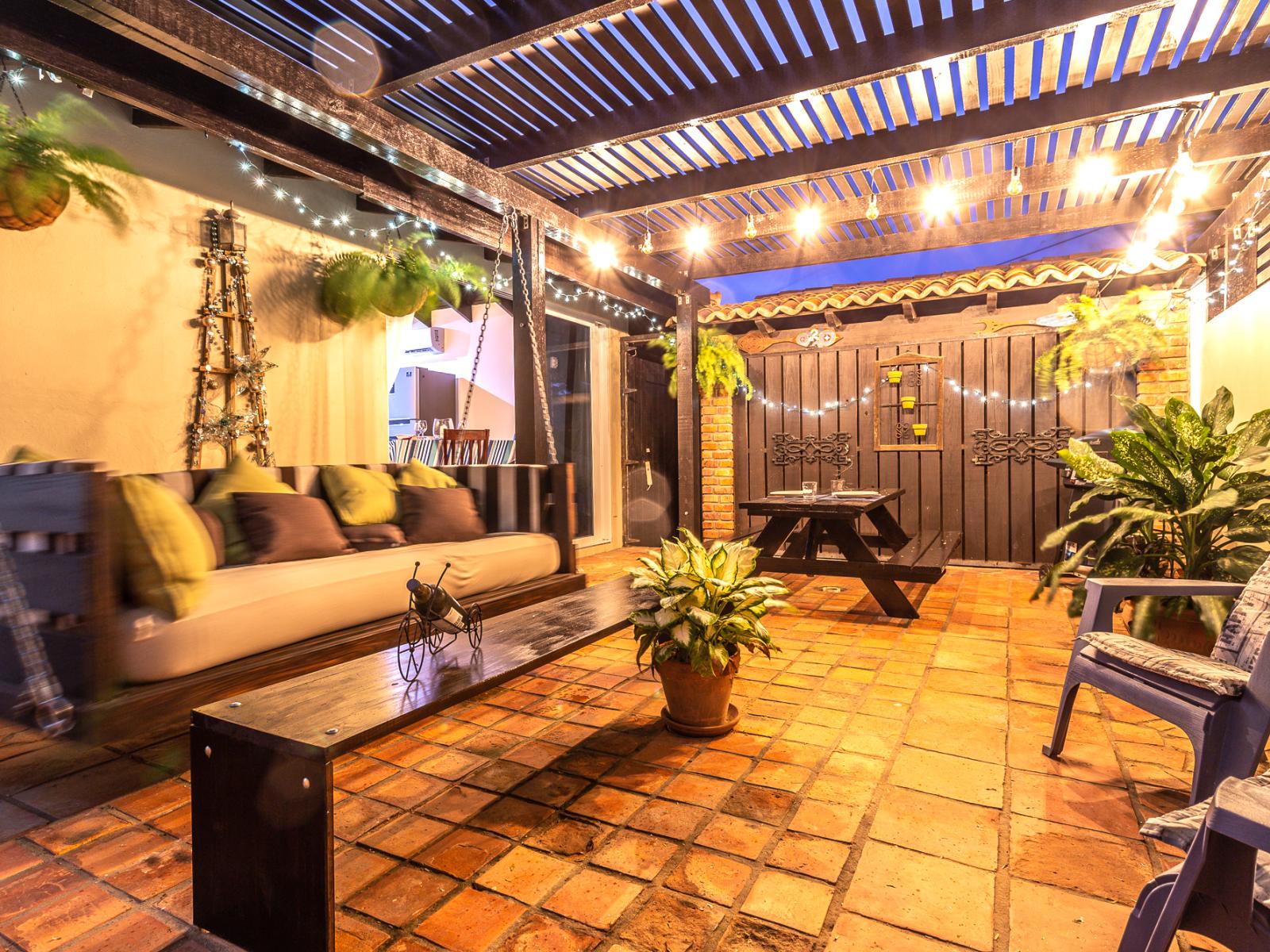 Pleasant outdoor seating area of the Apartment in Noord Aruba - Well-chosen lighting fixtures adding both functionality and charm - Cozy seating area conducive to relaxation and socializing