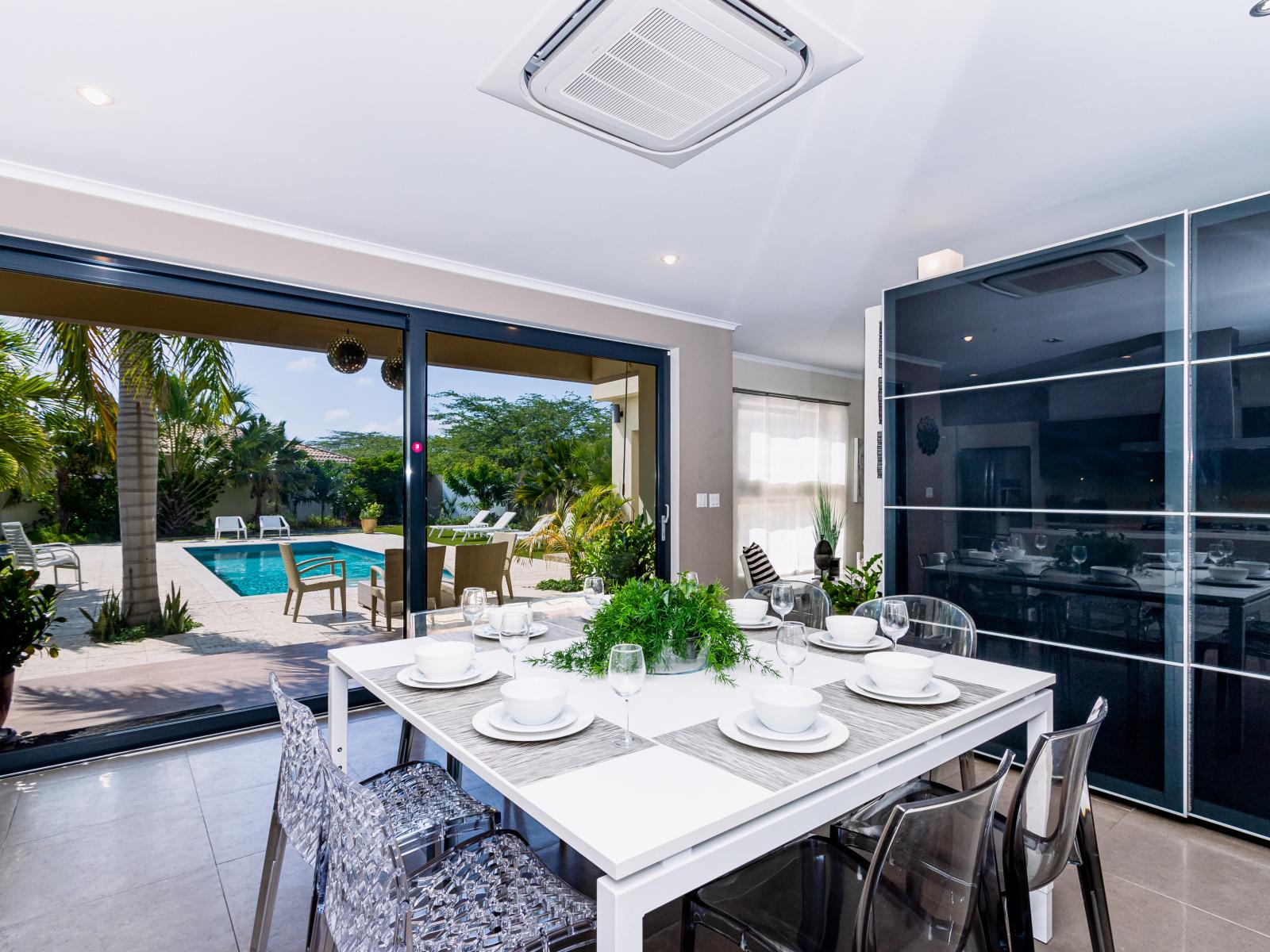 Eminent Dining Area of the villa in Noord Aruba Near beach - 8 Persons Dining - Neutral color palette with pops of vibrant hues for a chic contrast - Artfully arranged table settings for a touch of elegance