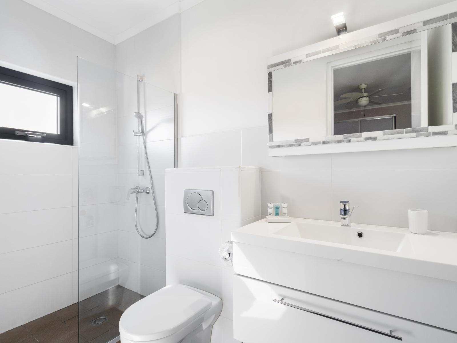 Refined Bathroom of the Villa in Noord Aruba near Paseo Herencia Mall - Ample natural light highlighting the elegant tilework - Functional yet glamorous, with thoughtfully chosen fixtures - Meticulous design, from elegant tiles to faucets