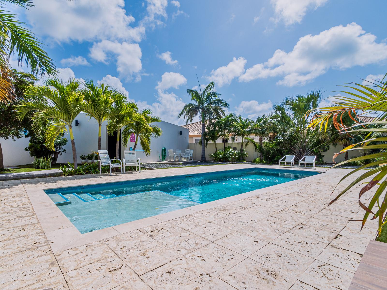 Cool off in our serene swimming pool, then lounge in comfort by the water's edge.