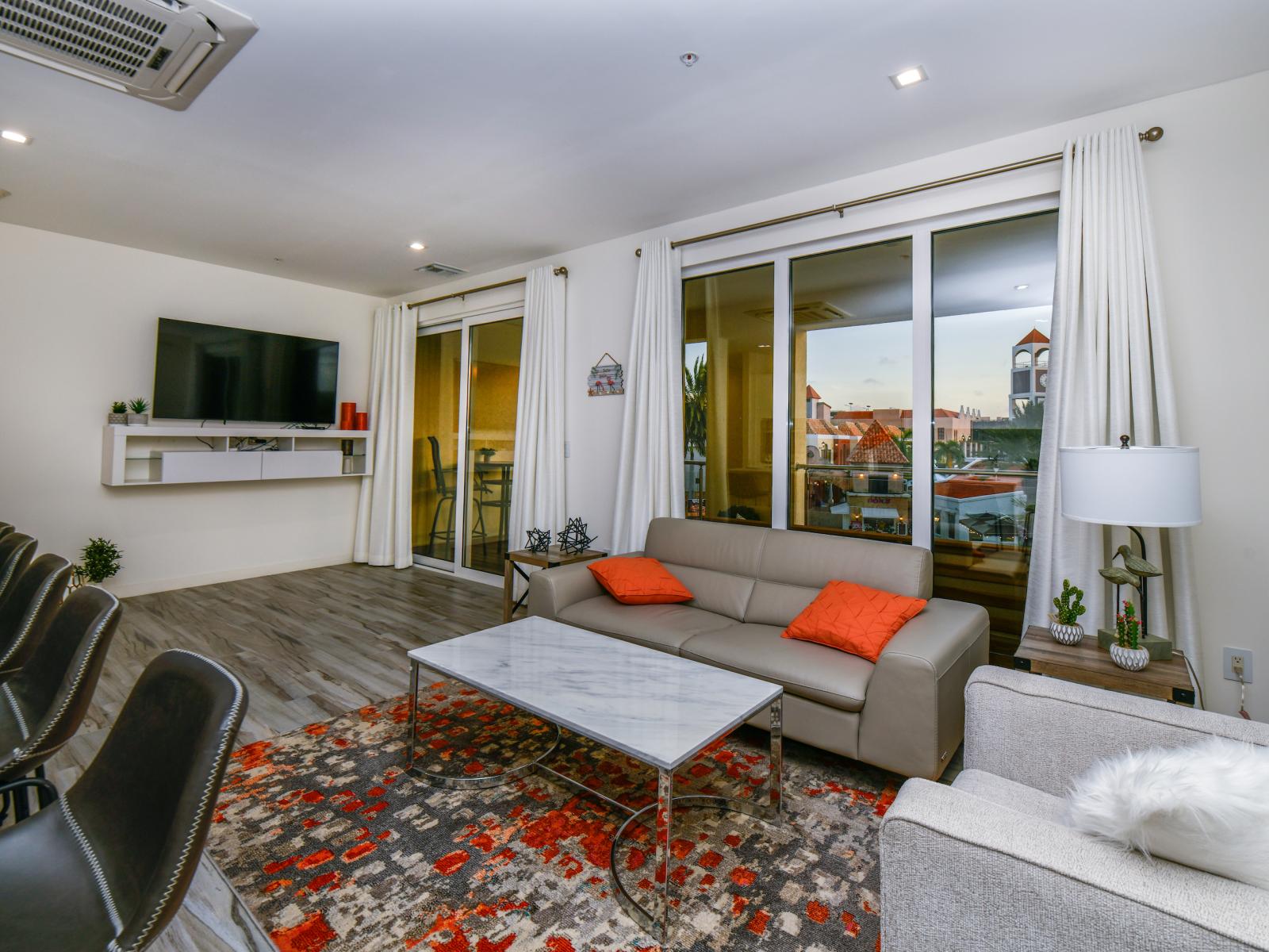 Luxe Living Area of the 2BR condo in Noord Aruba - Smart TV and Netflix - Stylish furniture arrangement providing comfort and a cohesive look - Comfy Seating - Large Windows with panoramic Views