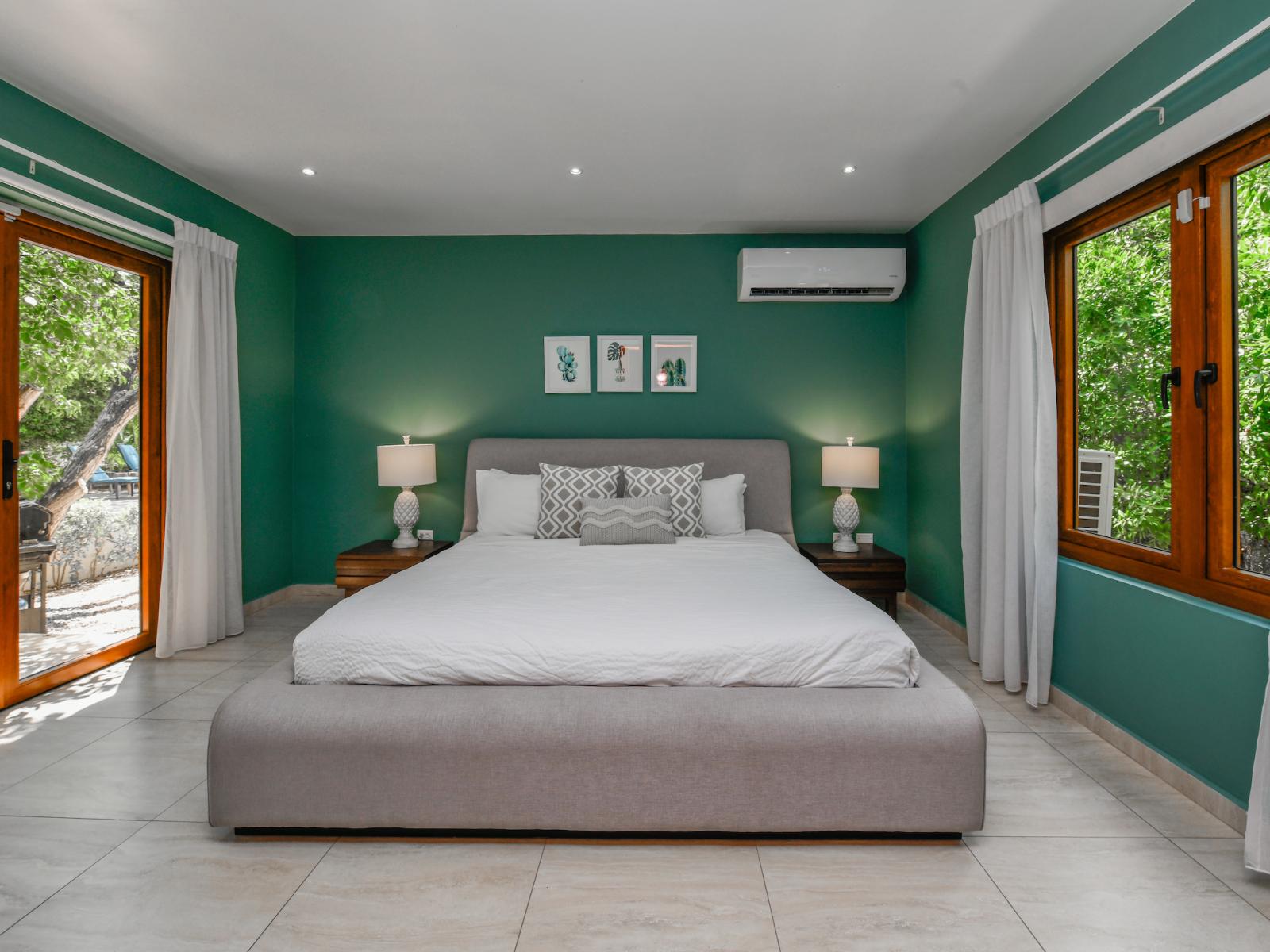 Luxurious bedroom of the villa in Noord, Aruba - Comfy king size bed - Elegantly designed room beautifully decored with large aesthetic wall paintings - Majestic table lamps - Neat and clean linen with soft pillows