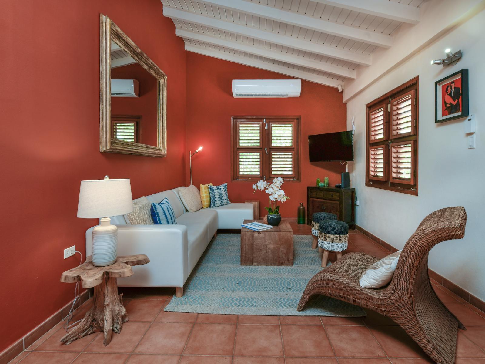 Lavish living area of the villa in Noord, Aruba - Cosy sofas - Beautifully located large windows of the villa with mesmerizing views - Elite ambiance - Beautifully decored with wall paintings - Availability of TV and Netflix