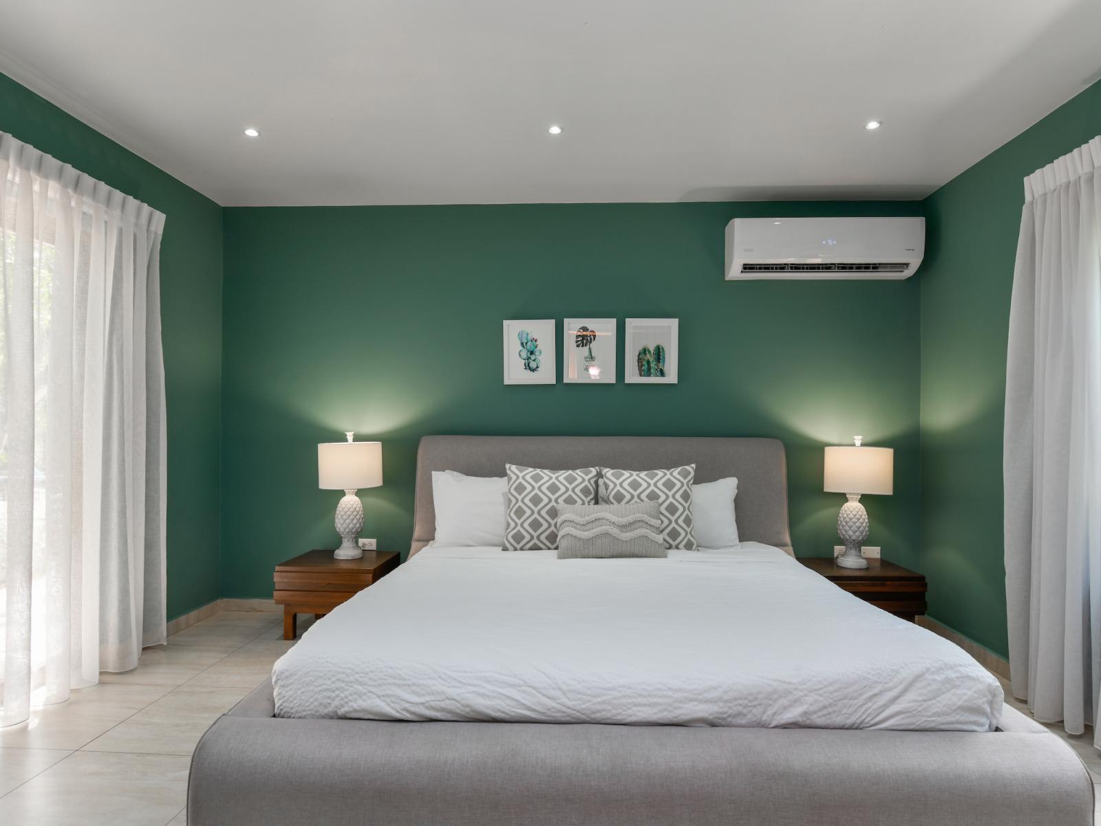 Indulge in comfort and convenience in Bedroom 1, complete with a luxurious king-size bed, a TV for entertainment, and an attached bathroom for privacy and relaxation.