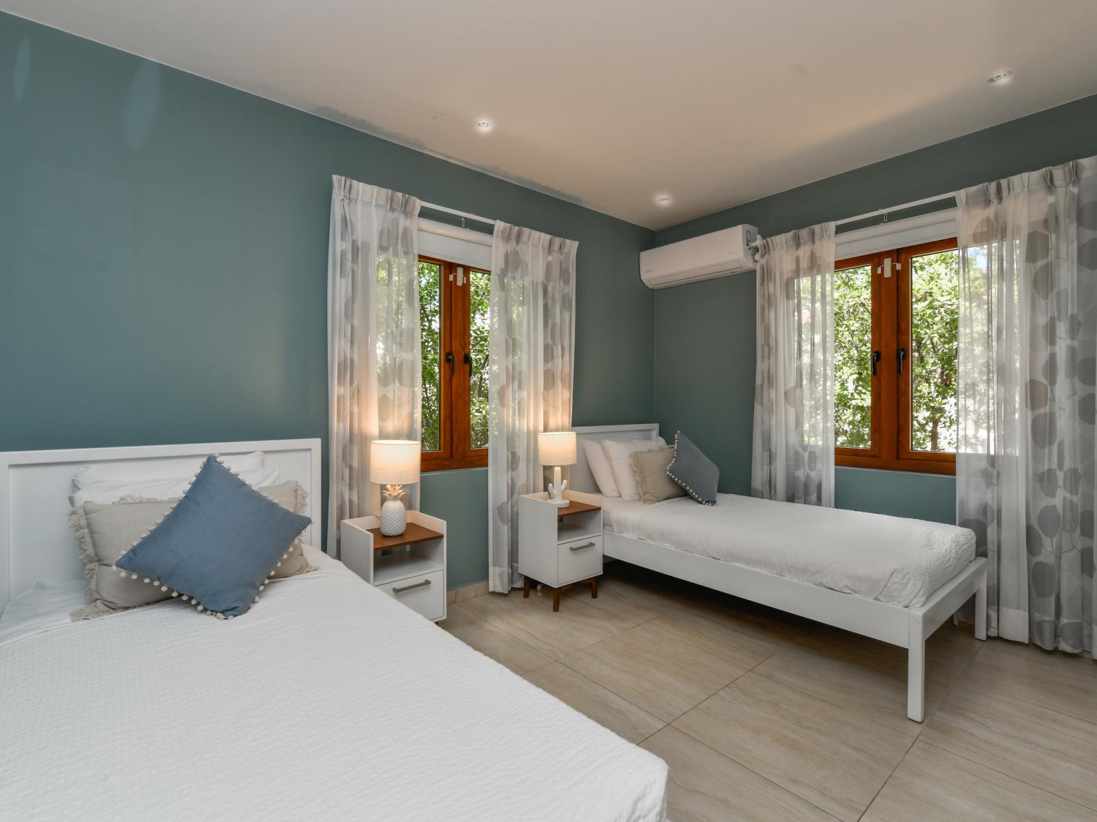 Glorious single beds bedroom of the villa in Noord, Aruba - Comfy 2 single beds - Elegantly designed room beautifully painted walls with aesthetic color scheme - Majestic table lamps - Neat and clean linen with soft pillows