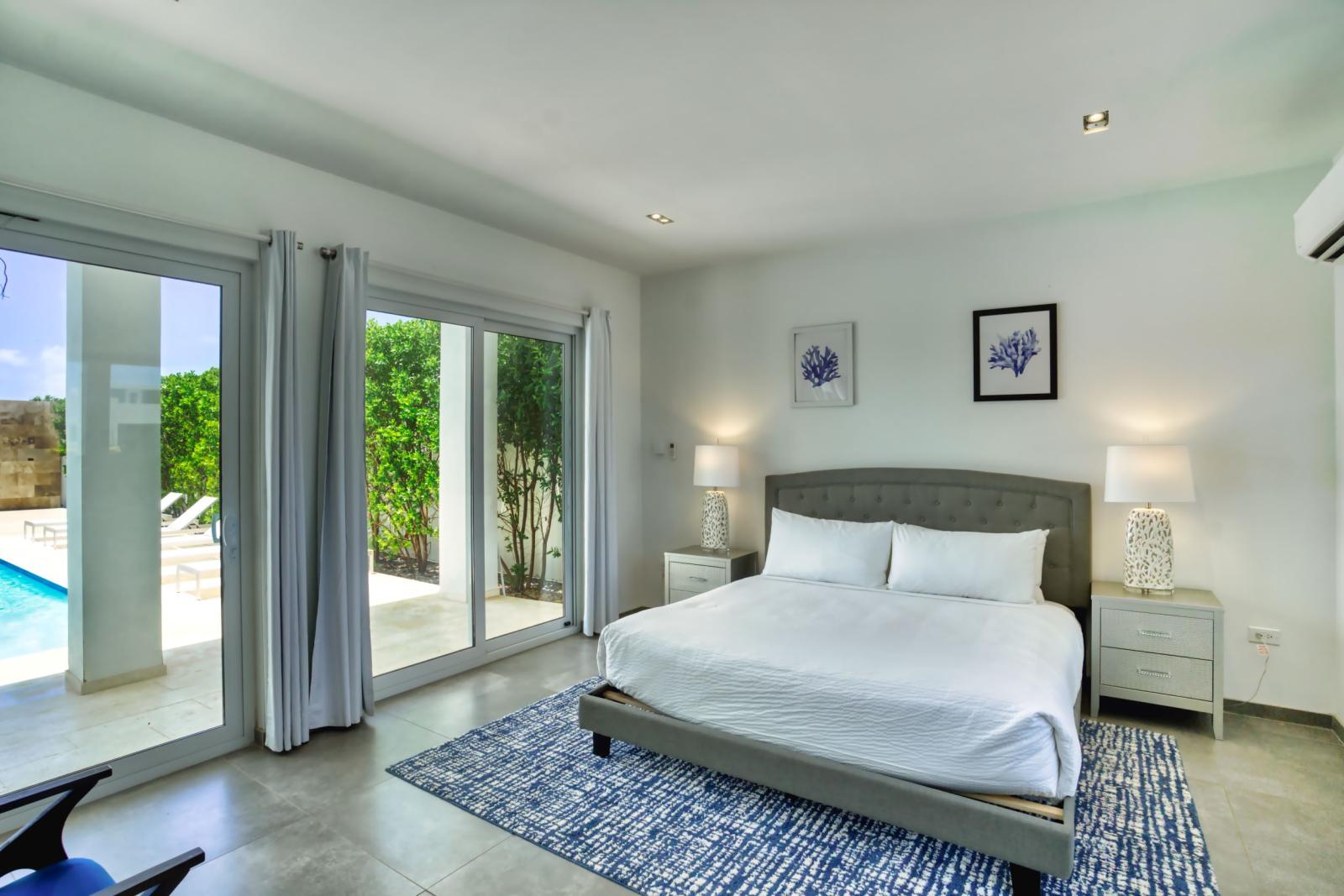 Deluxe Bedroom of the Villa in Noord Aruba - Full King Size Bed - Minimalist decor, creating a clean and uncluttered sleeping space - Cozy retreat with a plush bed, perfect for relaxation - Soft, lighting for a tranquil mood