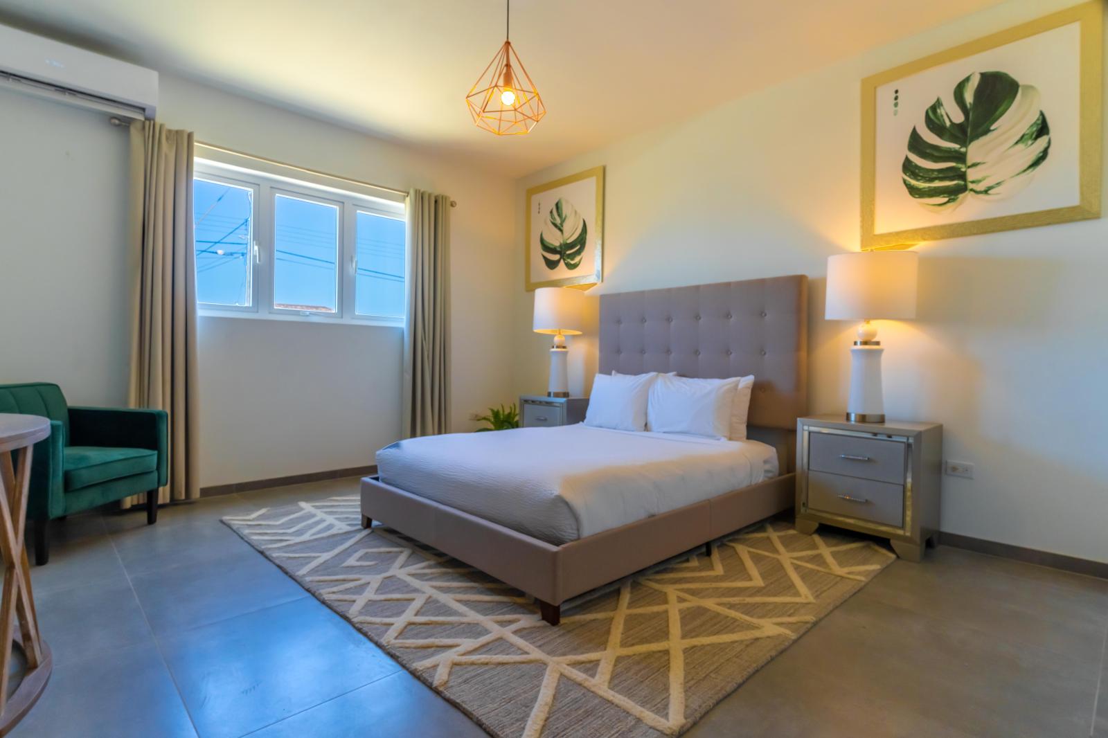 Fanciful Bedroom of the Villa in Noord Aruba - Cozy retreat with a plush bed, perfect for relaxation - Smart use of space with efficient storage solutions - Luxurious bedding for a restful night's sleep - Chic Lighting