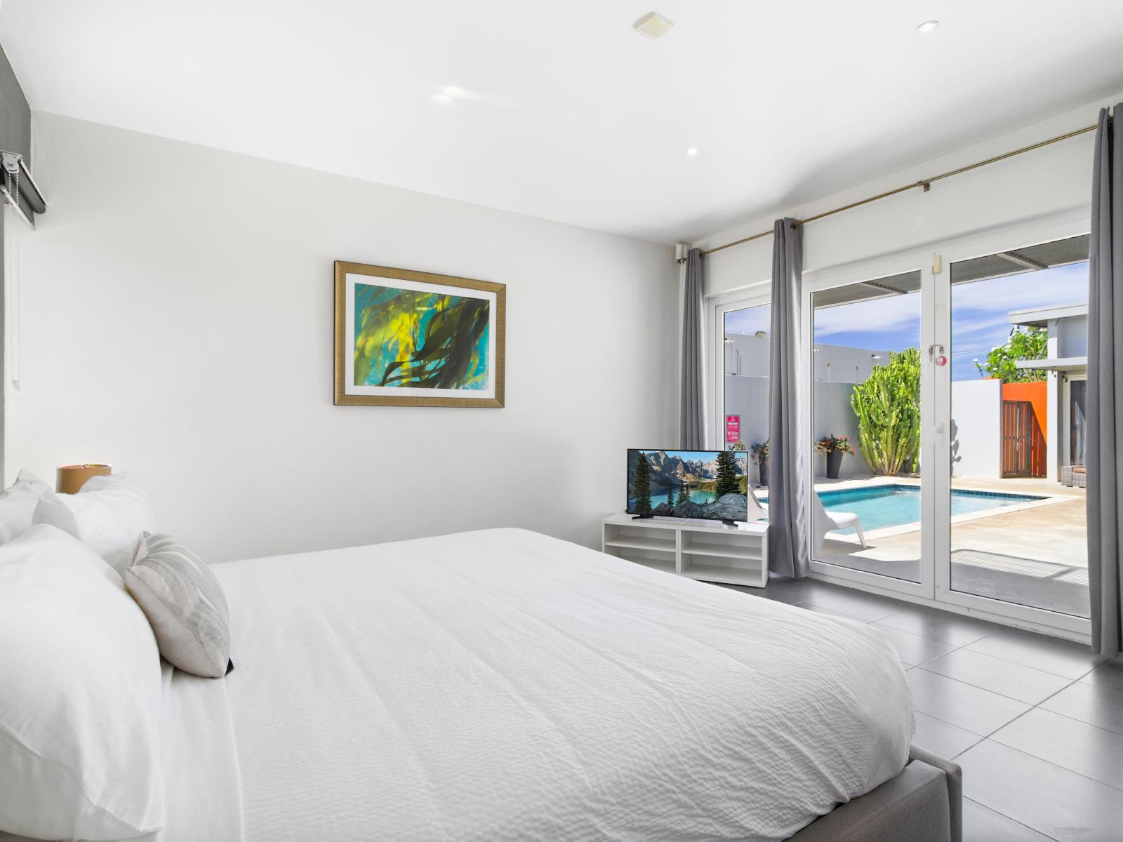 Experience luxury in Main Bedroom 1 with its king-size bed and scenic pool view.