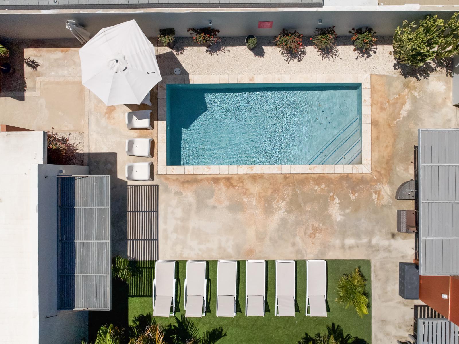 The aerial view of the home highlights its design and setting, offering a comprehensive look from above.