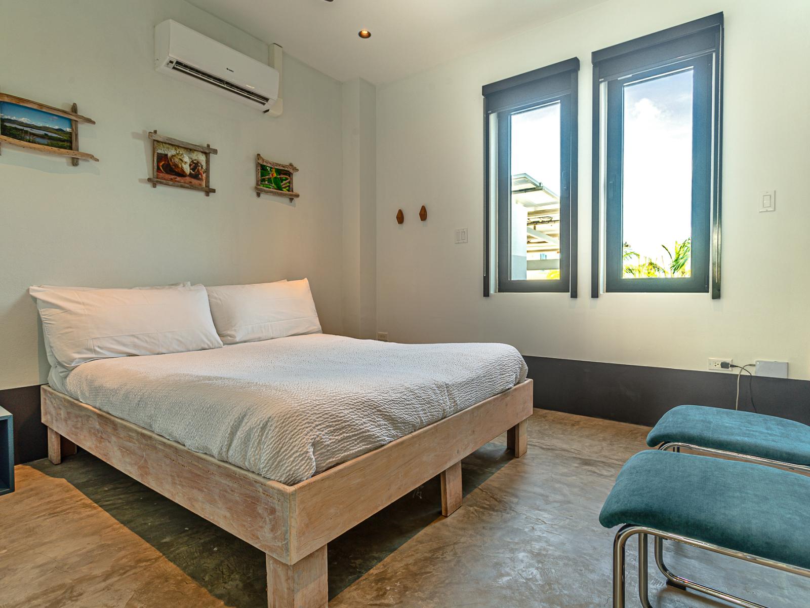 Bedroom 3 offers a Queen bed, a wall-mounted flat-screen televisions and a view of the backyard and pool