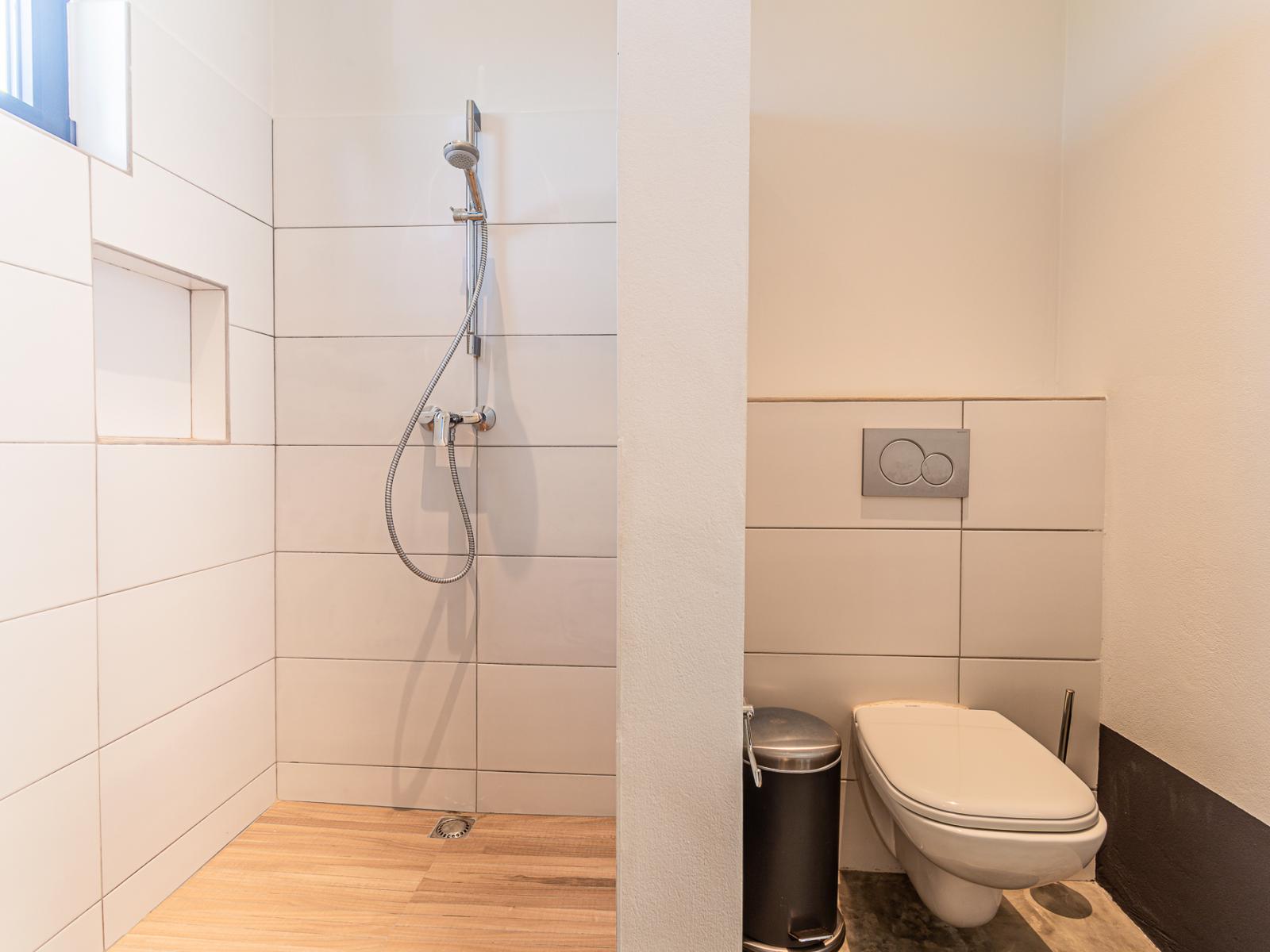 The walk-in shower, toilet, and vanity in Bathroom 2 create a practical and elegant bathing experience.