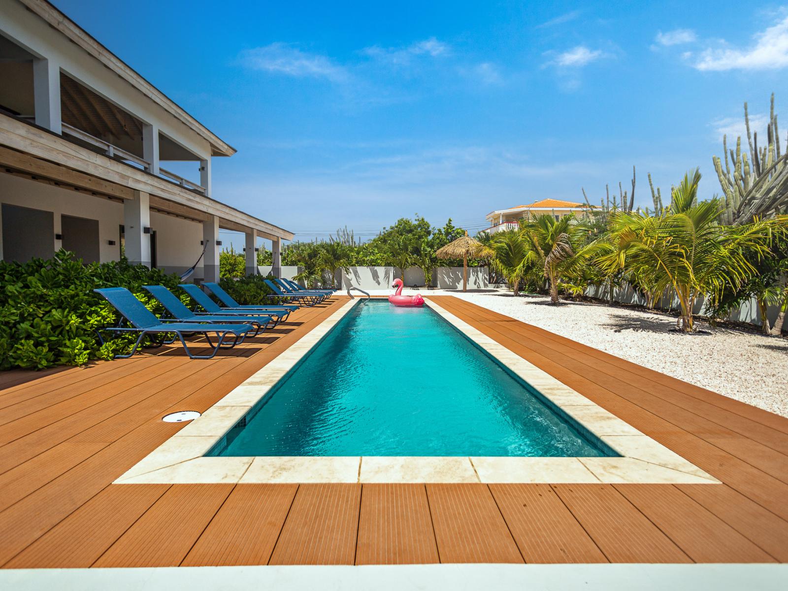 The pool is delicately lined with planked wood, shells, and palms