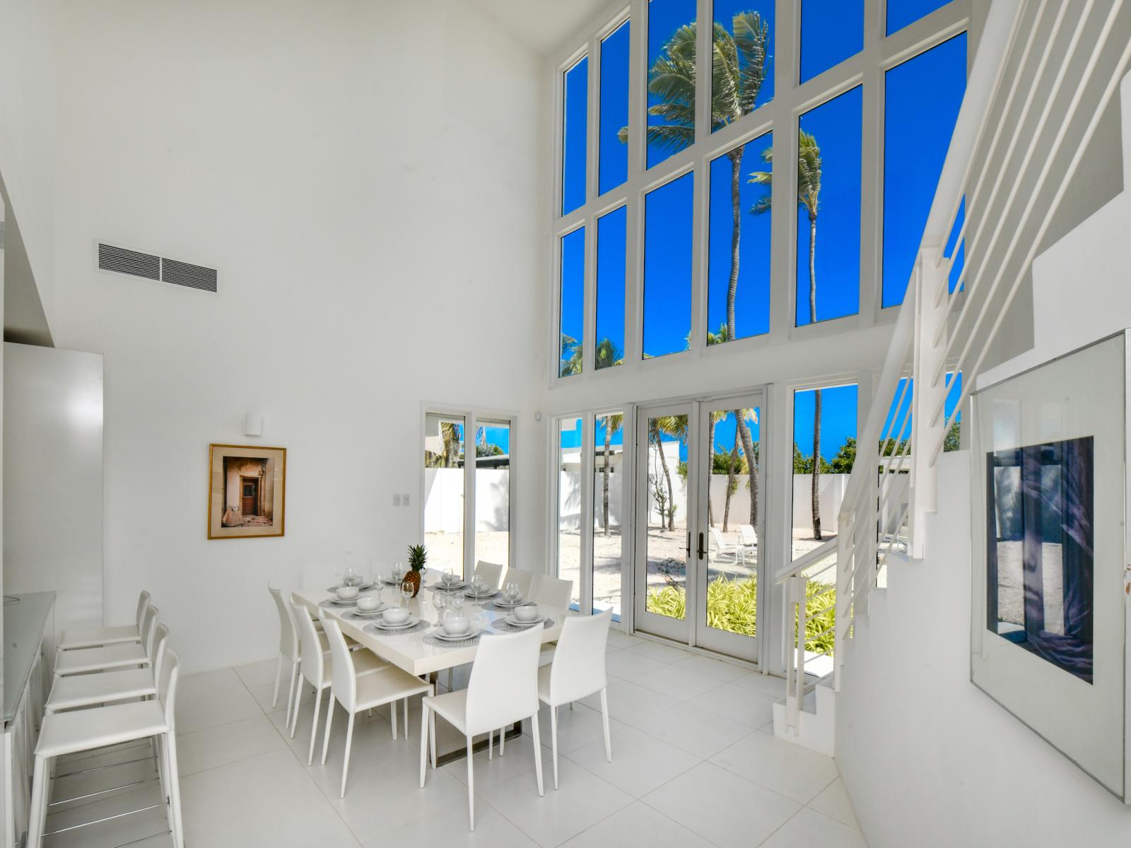 Ritardando Dining Area of the Villa in Noord Aruba - High ceilings creating sense of spaciousness - 8 Persons Dining - Floor-to-ceiling windows flood the space with natural light, offering stunning views