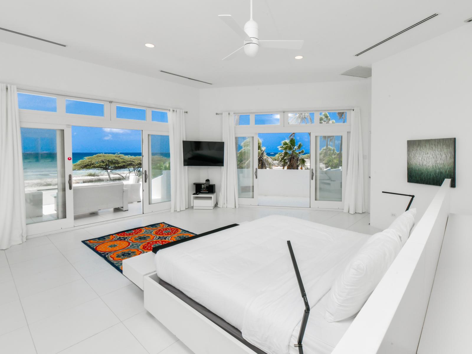 Spacious Bedroom of the Villa in Noord Aruba - King Size plush bed - Bright and airy bedroom with large windows for natural illumination - Smart TV and Netflix - Balcony with Ocean Views