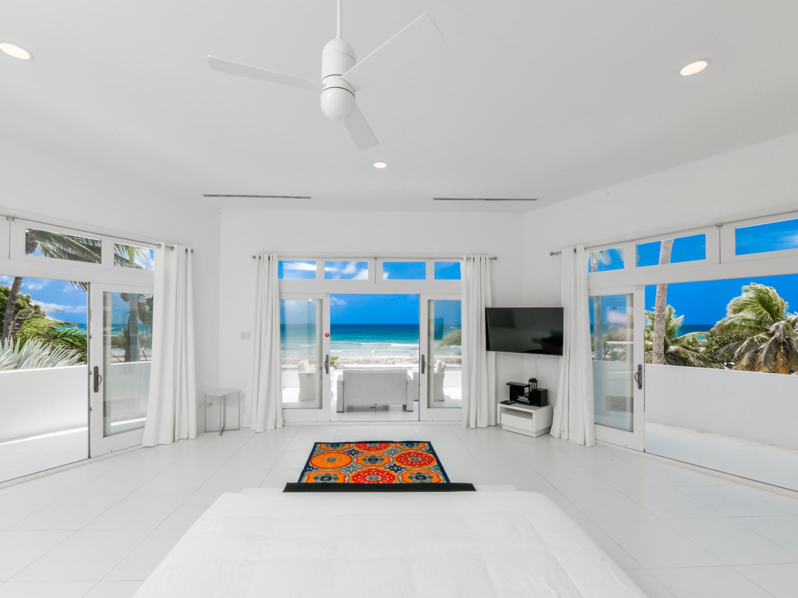 Relish in luxury and comfort in our main bedroom, featuring a plush king bed, personal TV, attached bathroom, and breathtaking ocean views—where relaxation meets unparalleled serenity.