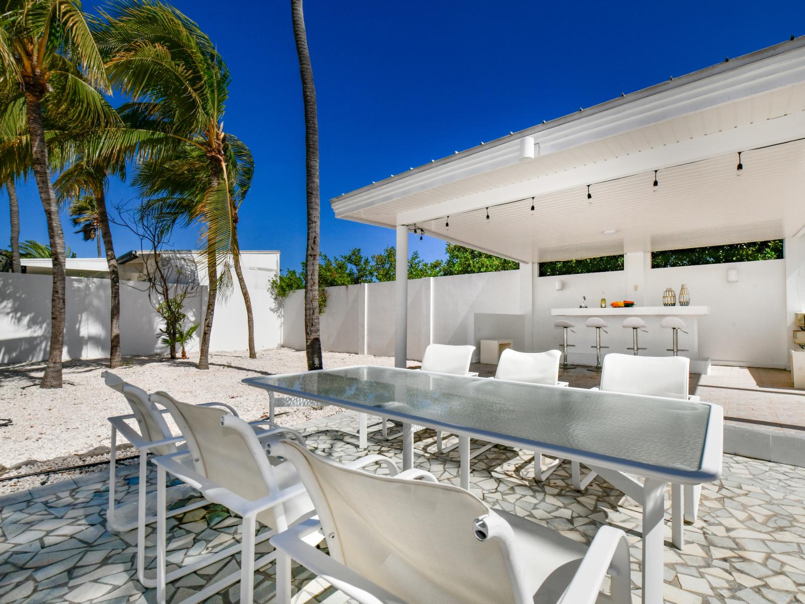 Refreshing Outside dining table by the pool of the Villa in Noord Aruba - Pool Bar - Dining for 6 Persons - BBQ Grill - Experience outdoor bliss with charming dining