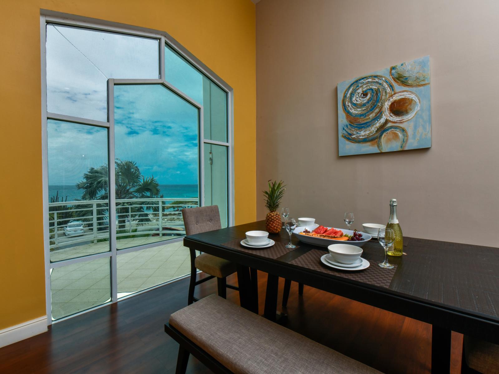 Lush Dining Area of the villa in Noord Aruba - Amazing ocean Views - Thoughtful lighting fixtures creating an intimate and inviting atmosphere - Dining for 4 Persons - Artfully arranged table settings for a touch of elegance