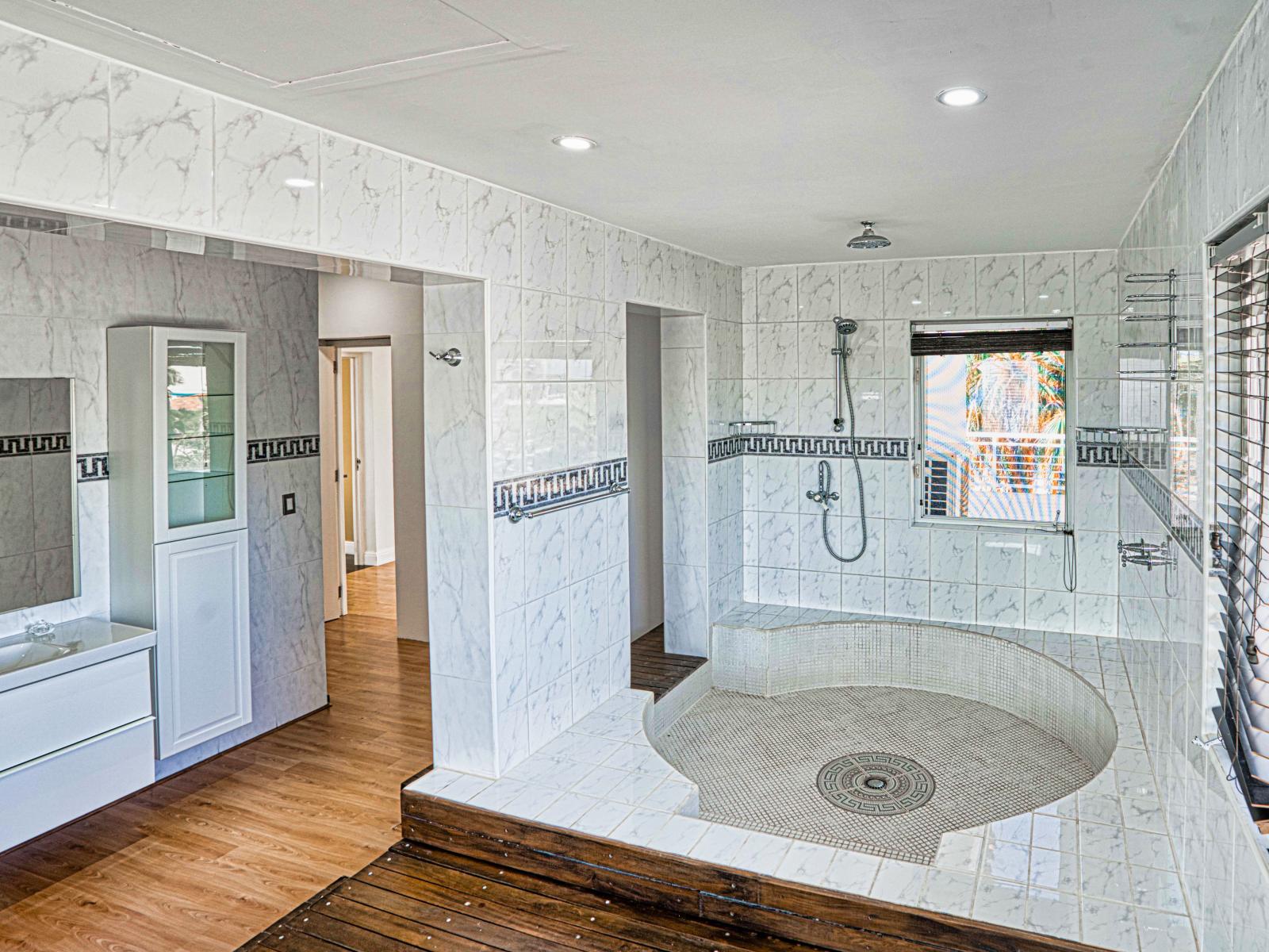 Majestic Bathroom of the villa in Noord Aruba - Sophisticated color palette creating a serene ambiance - Ample natural light highlighting the elegant tilework - Seamlessly designed shower area modern touch