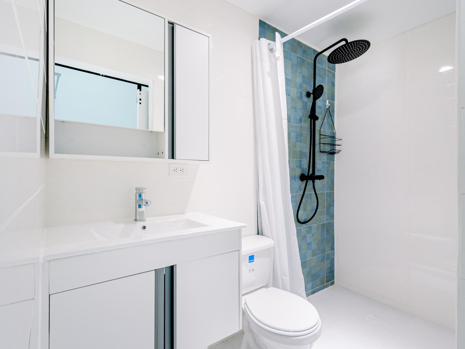 Enjoy convenience and luxury with our bedroom's attached bathroom, featuring a sleek walk-in shower for a refreshing and rejuvenating experience.