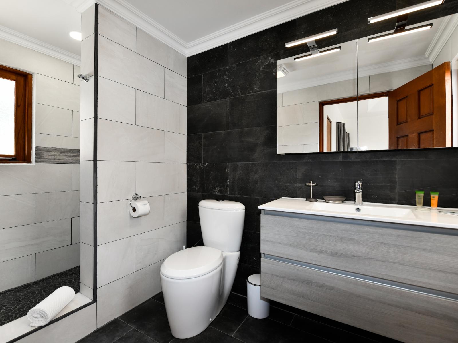 Upmarket Bathroom of the 3BR House in Noord Aruba - Elegant bathroom with luxurious fixtures and finishes - Walk in shower area - Chic vanity with large Mirror