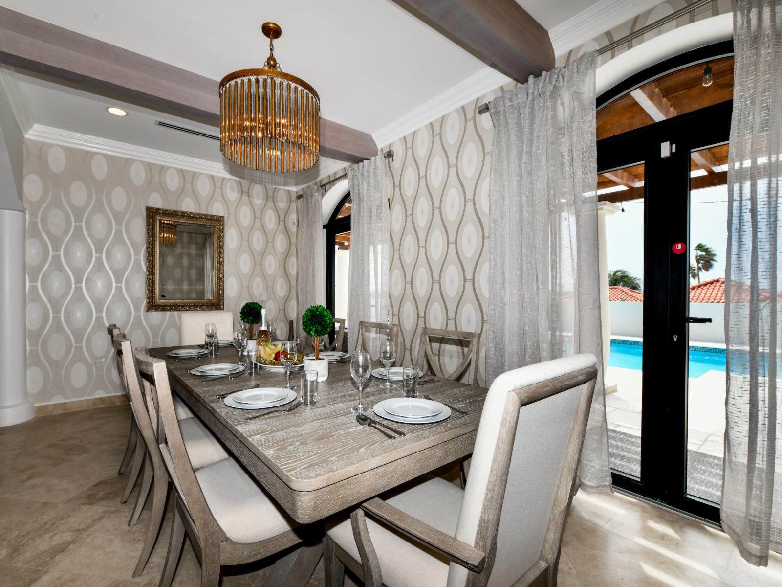 Refined Dining Area of the Villa in Noord Aruba near Palm Beach - Chic dining area featuring a stylish table and contemporary seating - 8 Persons Dining - Thoughtful lighting fixtures creating an inviting atmosphere - Majestic chandelier