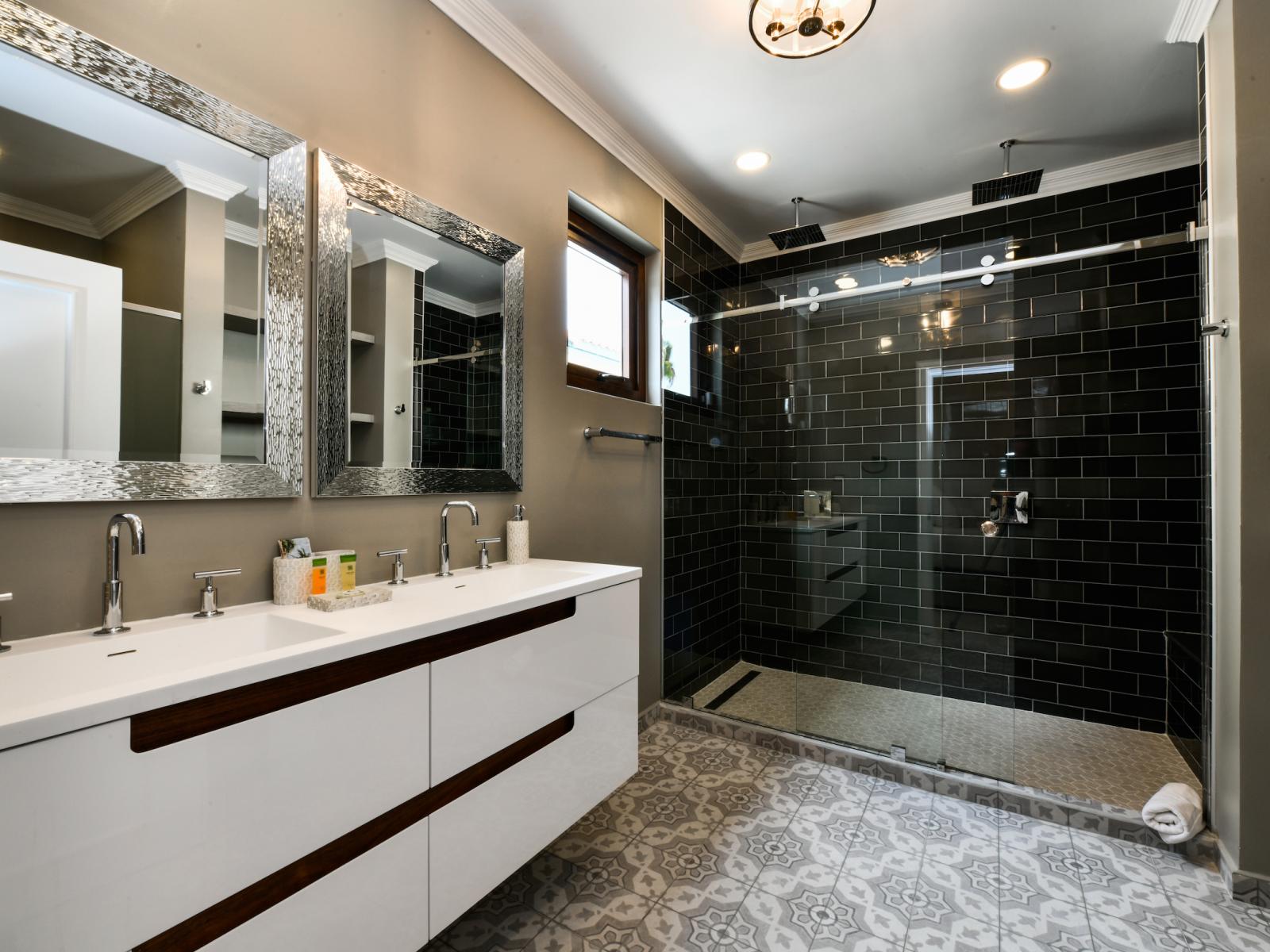 Lavish Bathroom of the Villa in Noord Aruba near beaches - Chic double vanity - Attention to detail, from the elegant tiles to the faucets - Spa-like atmosphere with a modern design - Glass enclosed shower Area