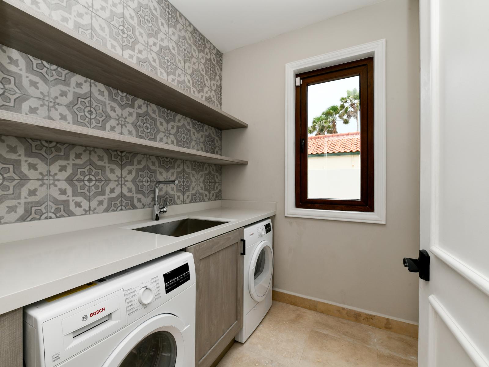 Neat Laundry room of the Villa in Noord Aruba - With a washer and dryer - Thoughtful storage solutions with stylish cabinets and shelves