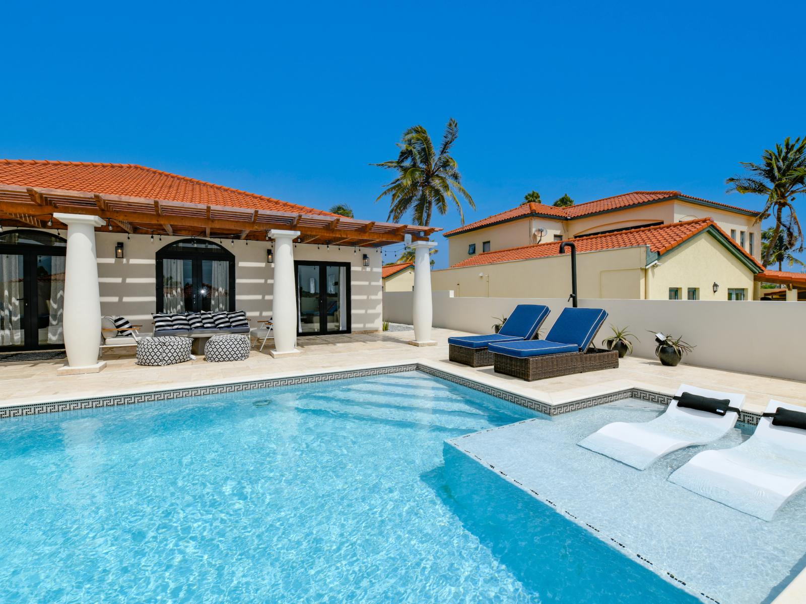 Refreshing pool of the Villa in Noord Aruba - With lounge chairs in the water for ultimate relaxation - Relax by the shimmering poolside oasis - Crystal-clear water