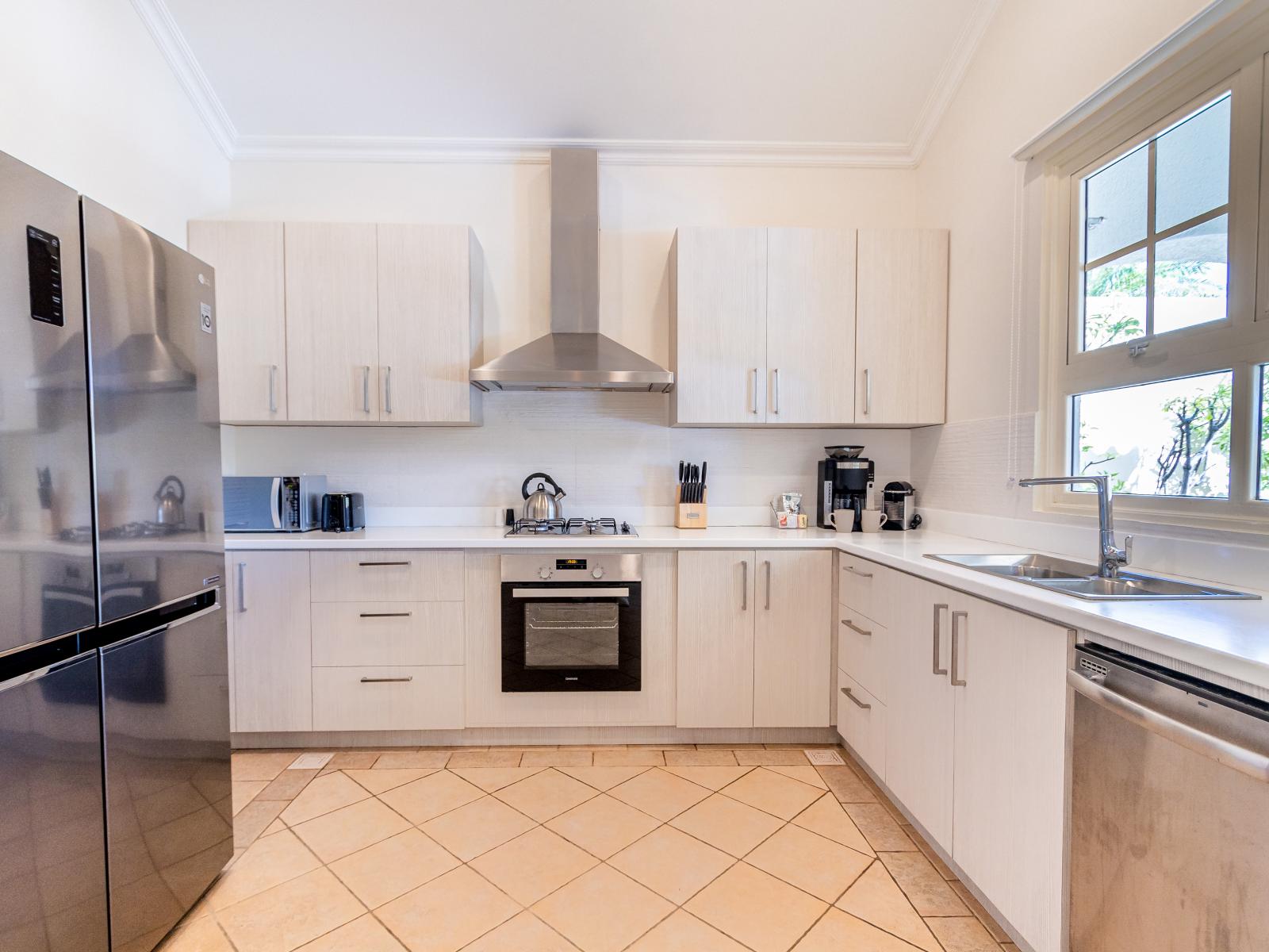 Modern Kitchen of the Villa in Aruba - Fully equipped - Smart use of space with versatile storage solutions - Integrated appliances for a seamless and stylish appearance - Large window with lush Views