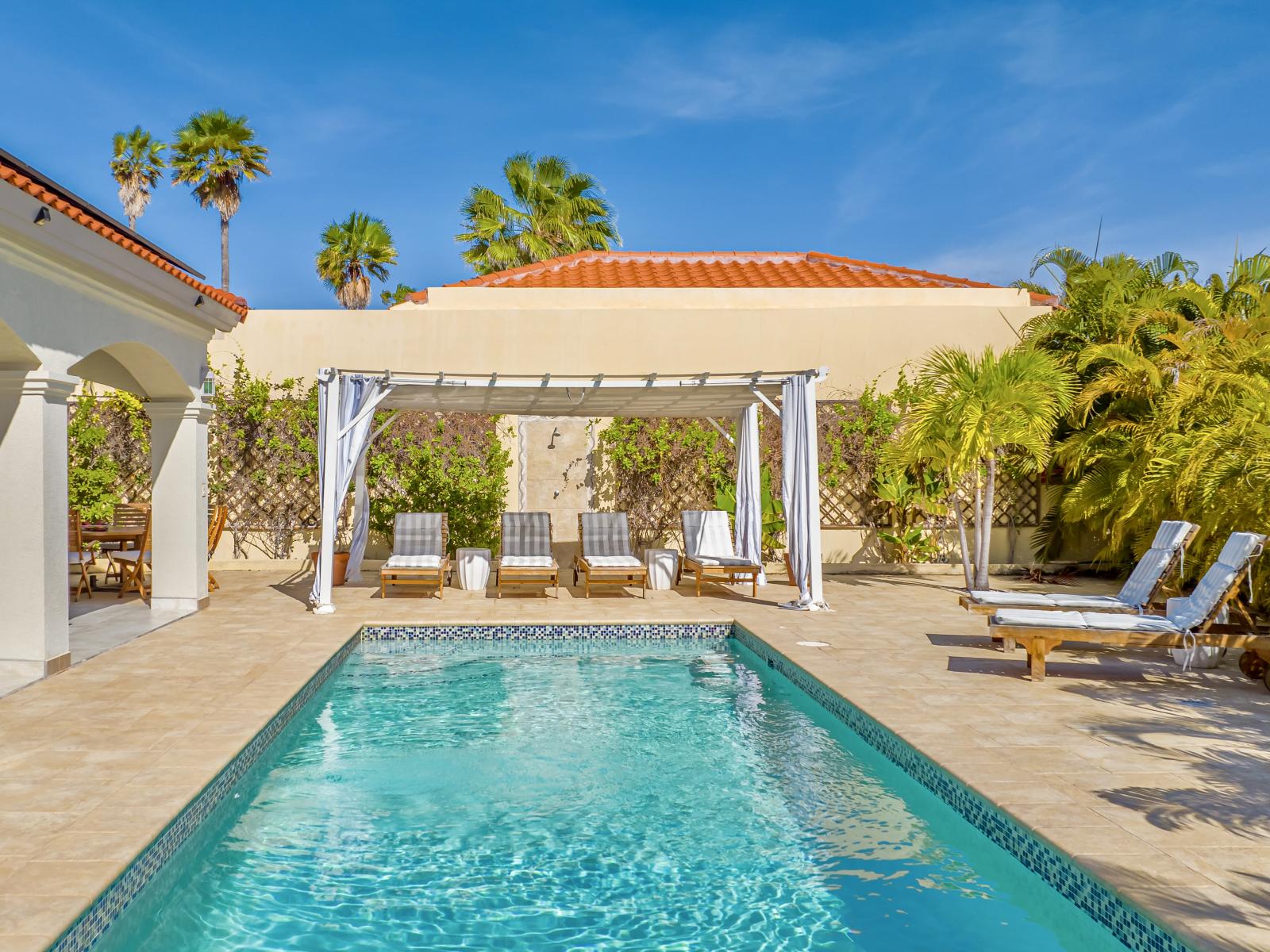 Cool off in our serene swimming pool, then lounge in comfort by the water's edge