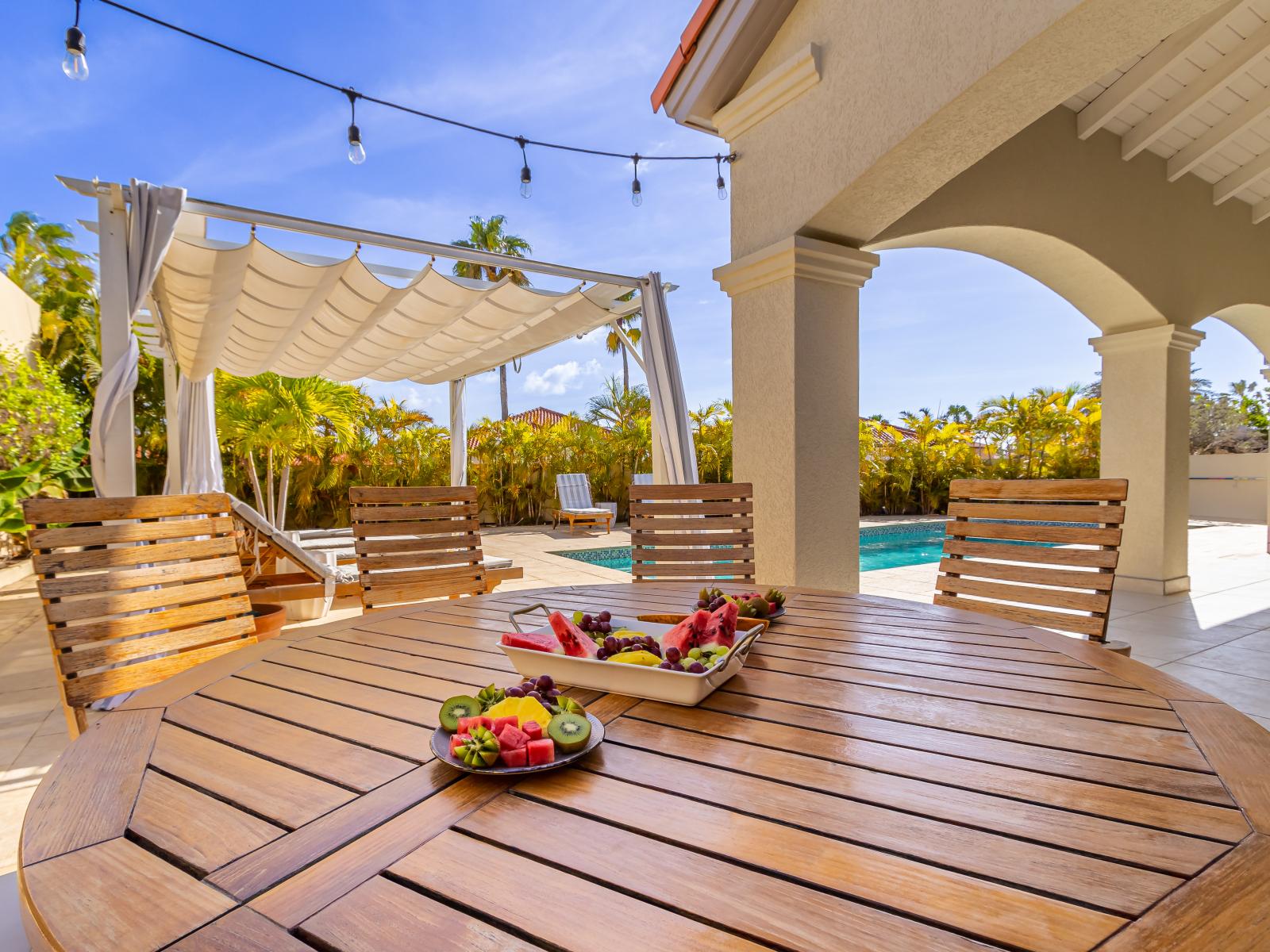 Outdoor dining area around the pool, perfect for al fresco meals and relaxing.