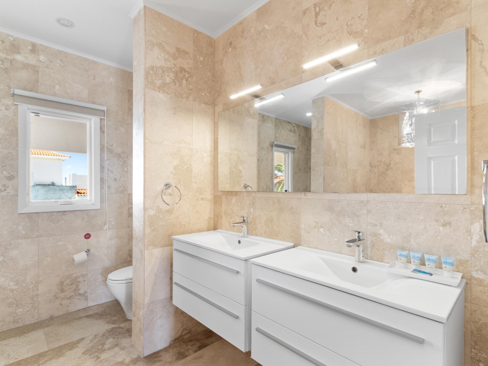 Well-Designed Bathroom of the Villa in Aruba near Palm Beach - Chic double vanity with Large mirror - Spa-like atmosphere - Contemporary fixtures for a touch of indulgence