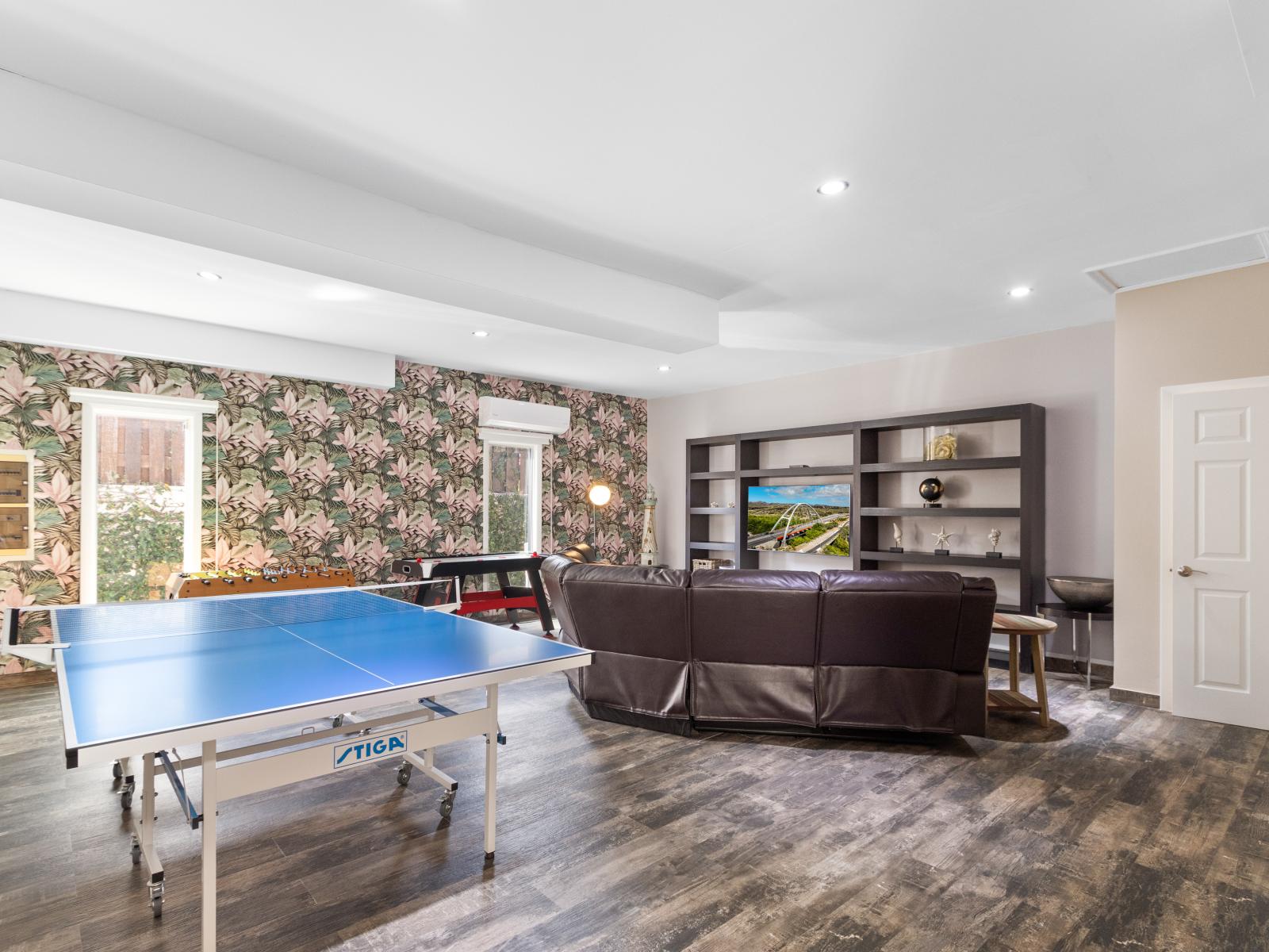 Lofty Game Room of the Villa in Aruba - Fully equipped game room with Table tennis, air hockey, and more - Perfect space for family bonding or friendly competitions - Cozy seating area for relaxation and unwinding after a day of fun