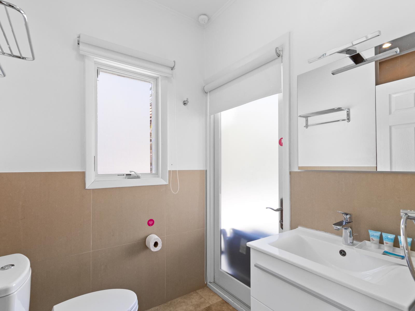 Classy Bathroom of the Villa in Noord Aruba - Beautiful Vanity with large size wall mirror - Sufficient storage space - Neat and clean toilet seat - Availability of all bathroom amenities - Stunning shower area