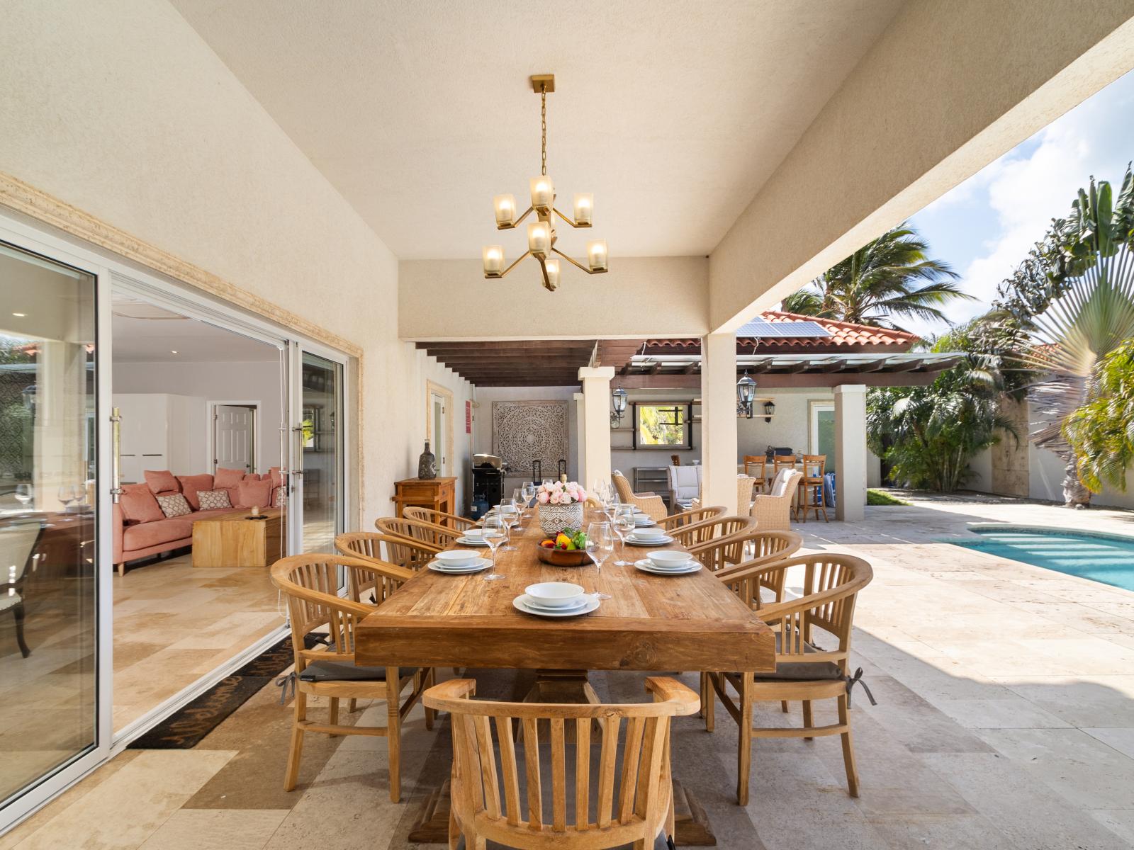 Elite outdoor dinning area of the Villa in Noord Aruba - Beautiful 10 persons dinning - Majestically decored space with refreshing Atmosphere - Superbly sunbathed space with umbrella shade - Outstanding pool facing dinning area - Beautiful view