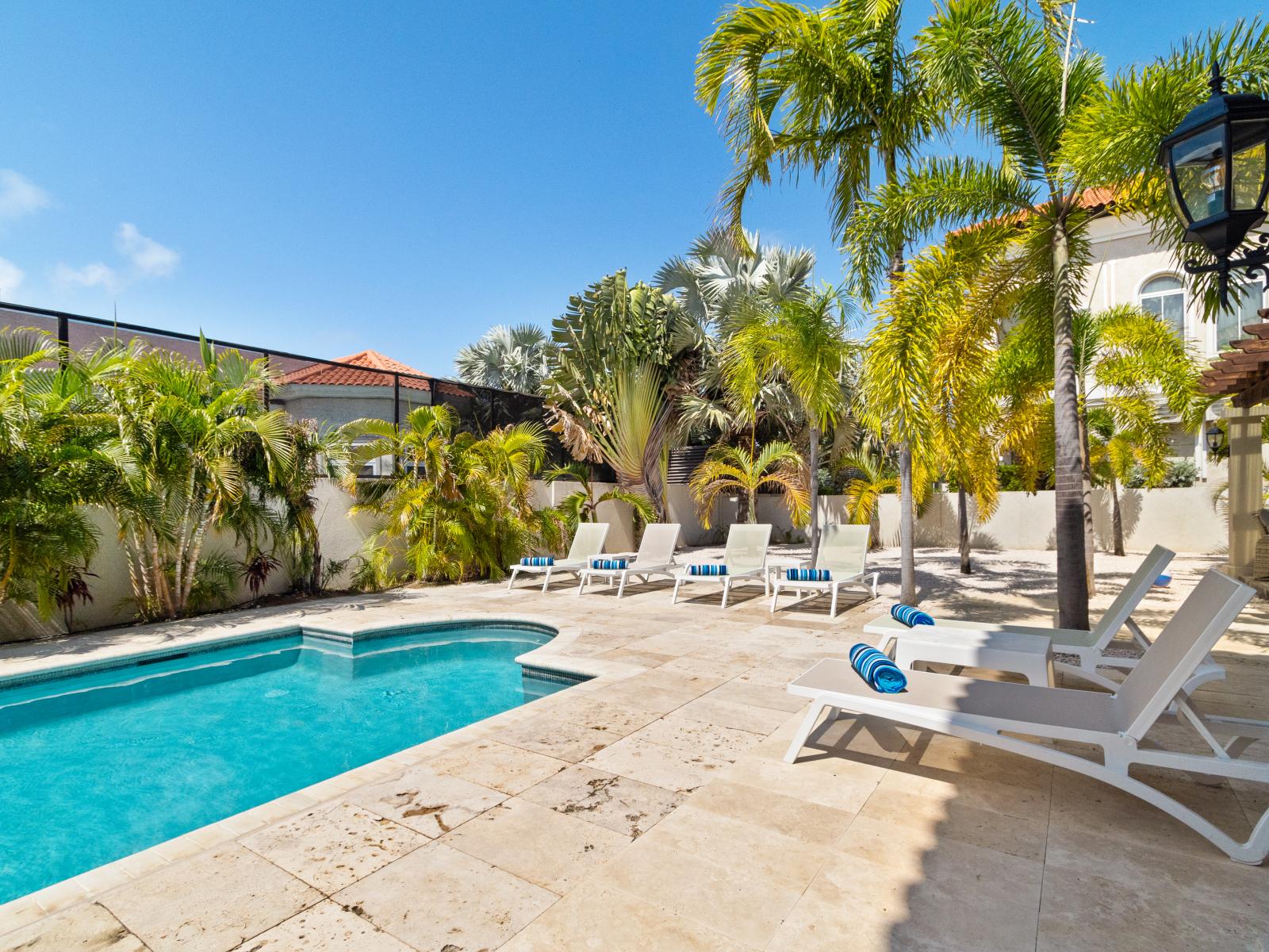 Relax on lounging chairs by the poolside.