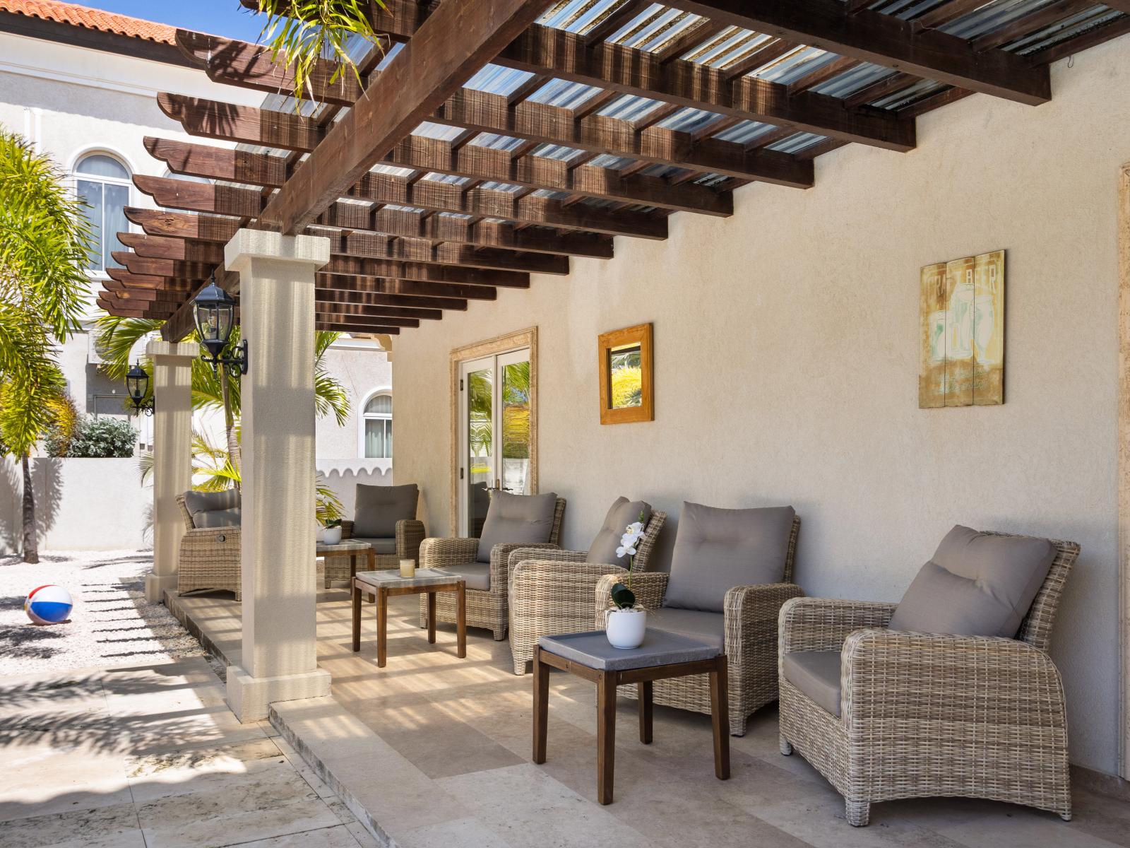 Lush outdoor Seating Area of the Villa in Noord Aruba - Perfect Spot for Pictures - Refreshing Atmosphere - Beautifully painted wall - Magnificently decored with refreshing plants pots