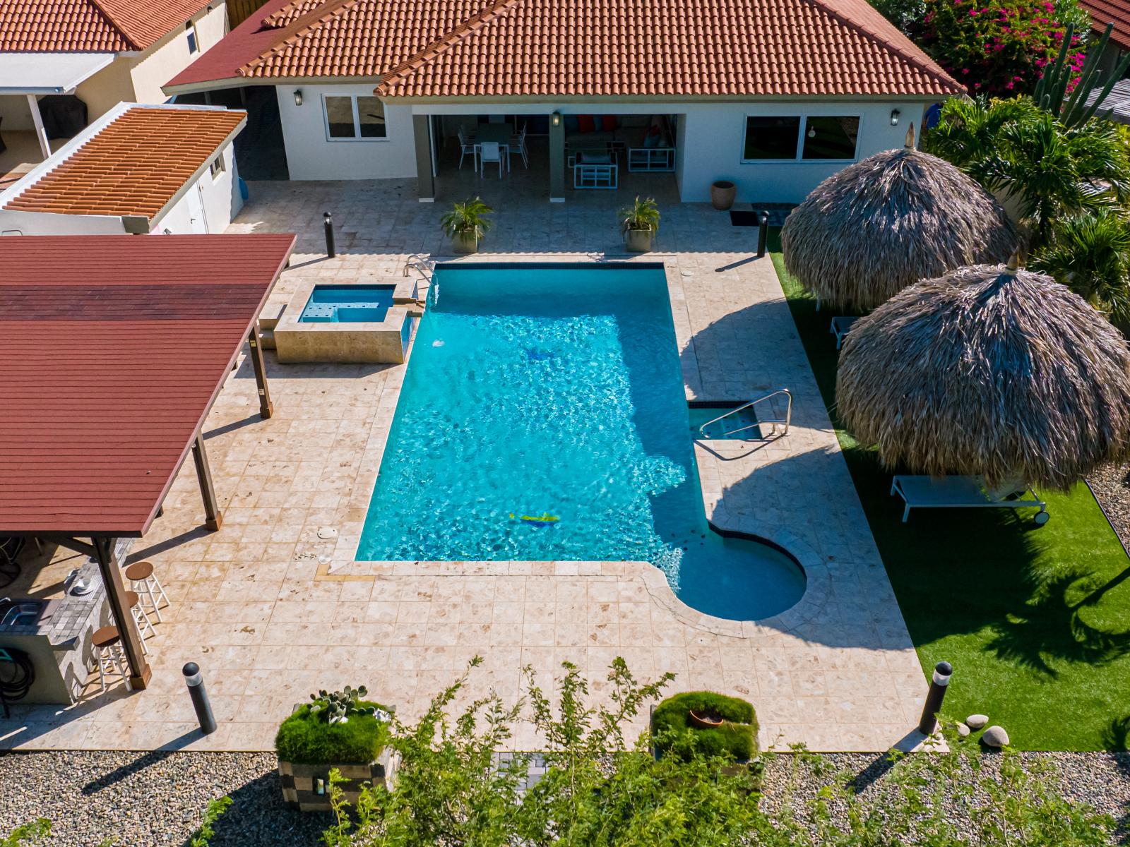 Refreshing large pool great for families with kids - Experience ultimate relaxation in our poolside paradise - Discover bliss by the pool in serene setting - Inviting pool area for a perfect getaway - Surrounded by tropical Trees