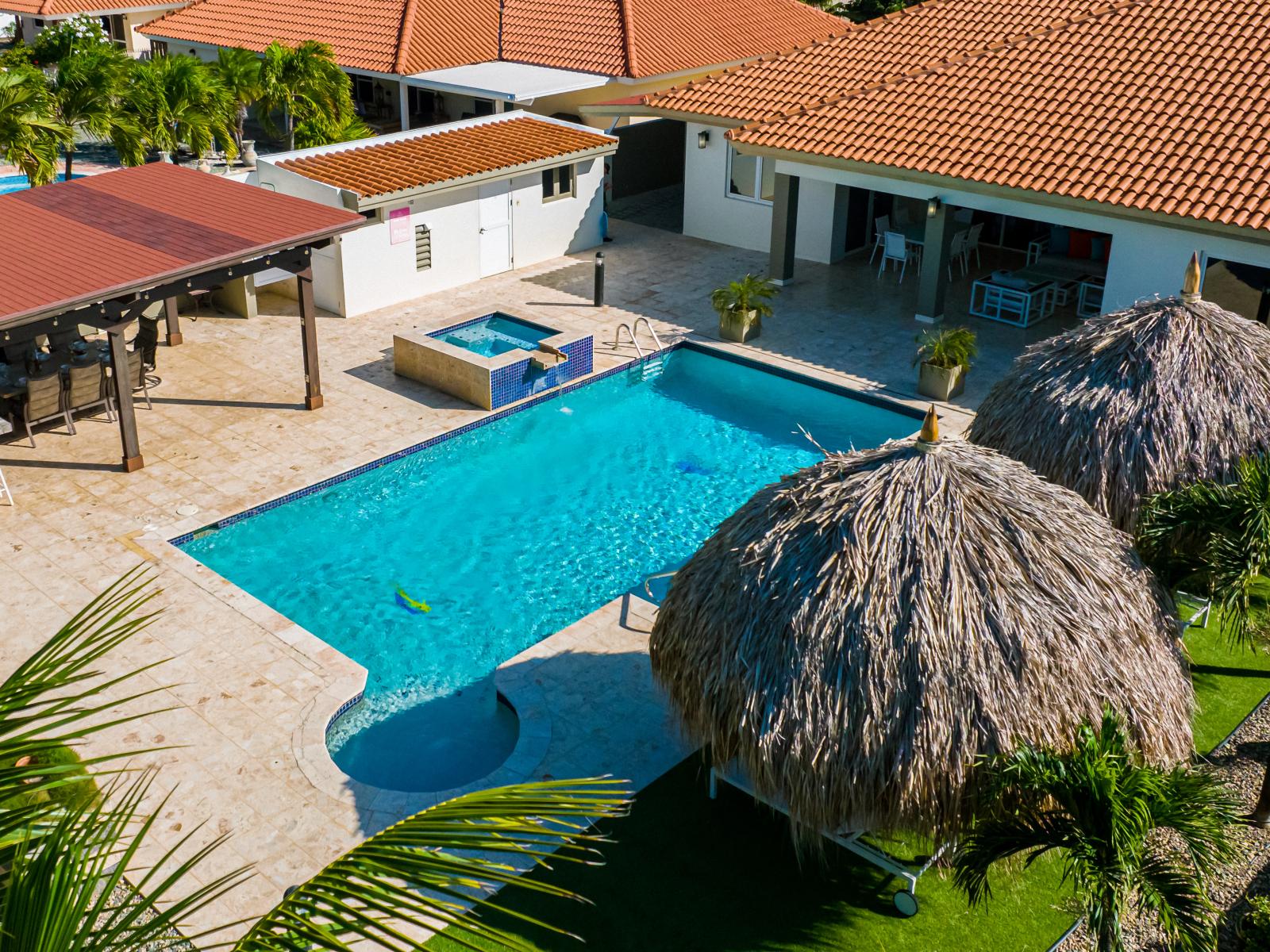 Luxury pool area of the Villa in Noord Aruba - Lush and refreshing environment - Cozy beach chairs available - Beautifully sunbathed space makes the soul peaceful - Experience the comfort at the best