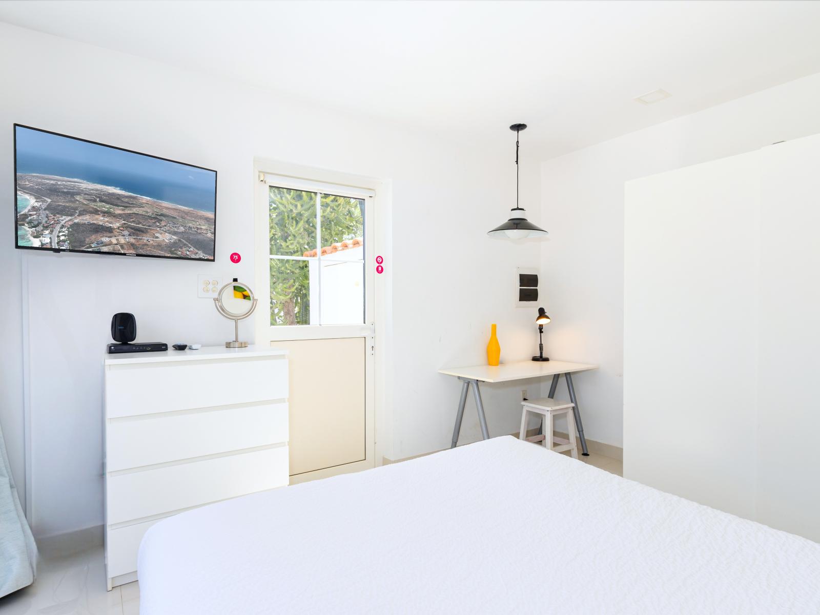 Bedroom 3 with access to the backyard and a wall mounted flat screen TV