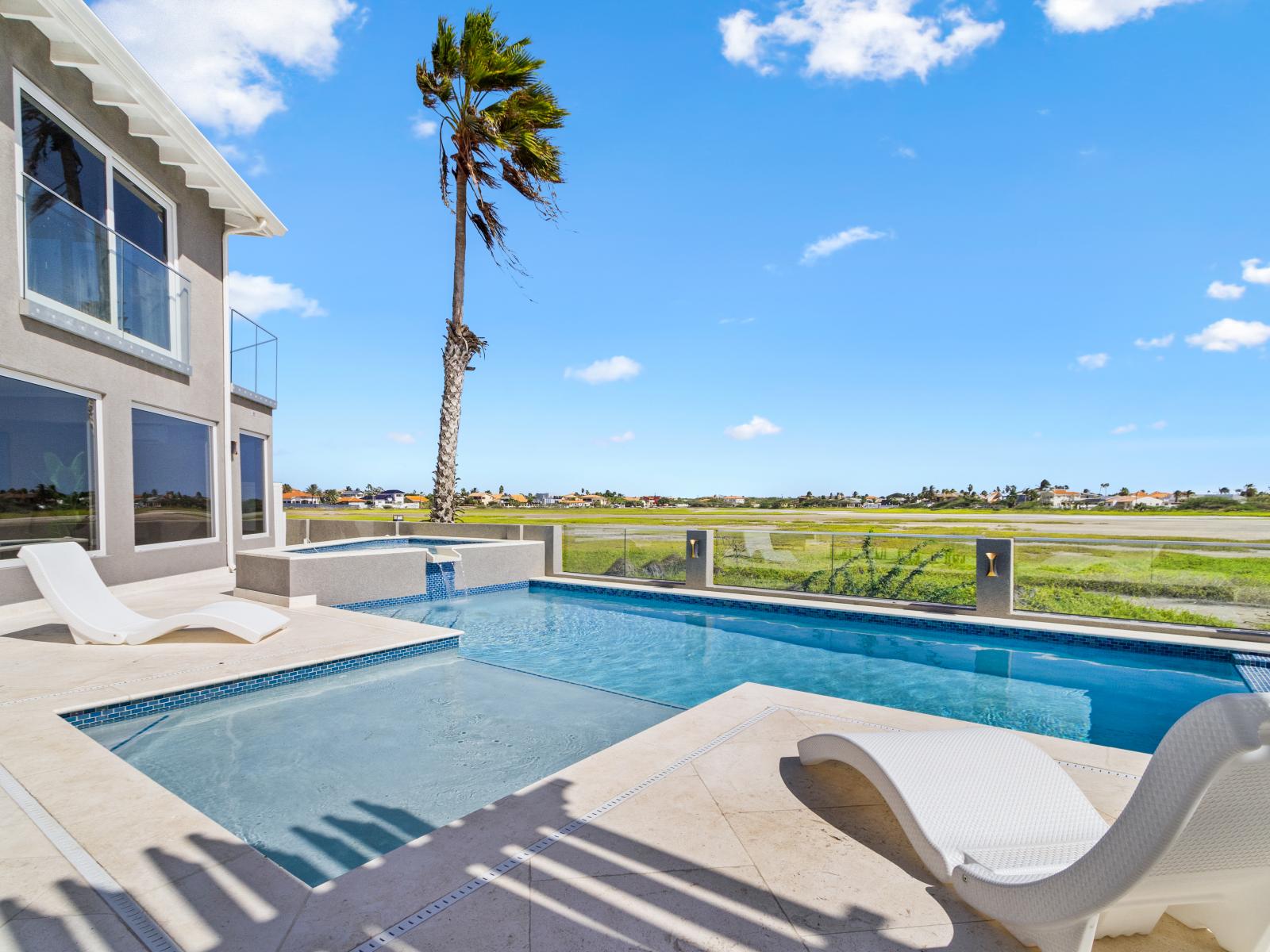 Stunning pool with gorgeous Saliña views in Noord Aruba - Provides a relaxed atmosphere for unwinding - Poolside chairs perfect for sunbathing and relaxation - Palm trees and tropical plants enhance the vacation feel