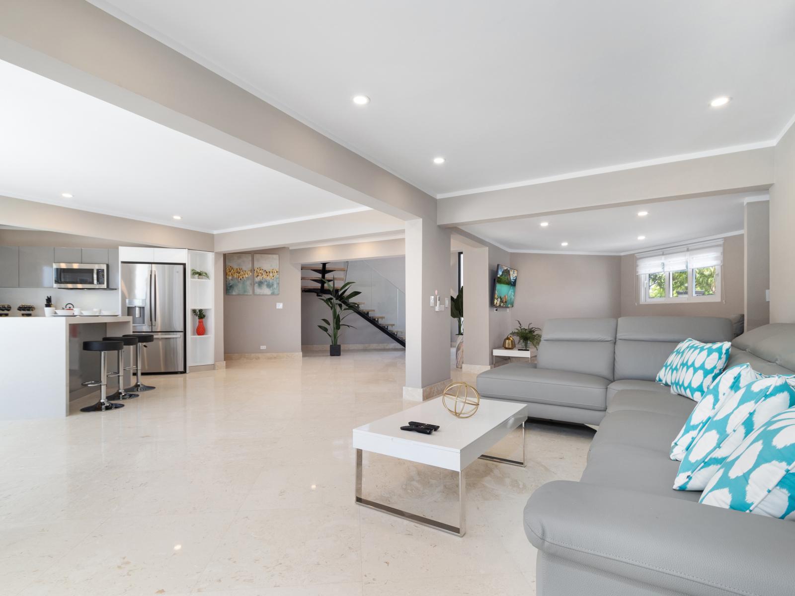 Spacious Living Area of the Villa in Noord Aruba  - Beautiful living room with an open layout, creating a sense of spaciousness - Open-concept living area seamlessly connected to a Kitchen - Well-chosen lighting fixtures adding functionality