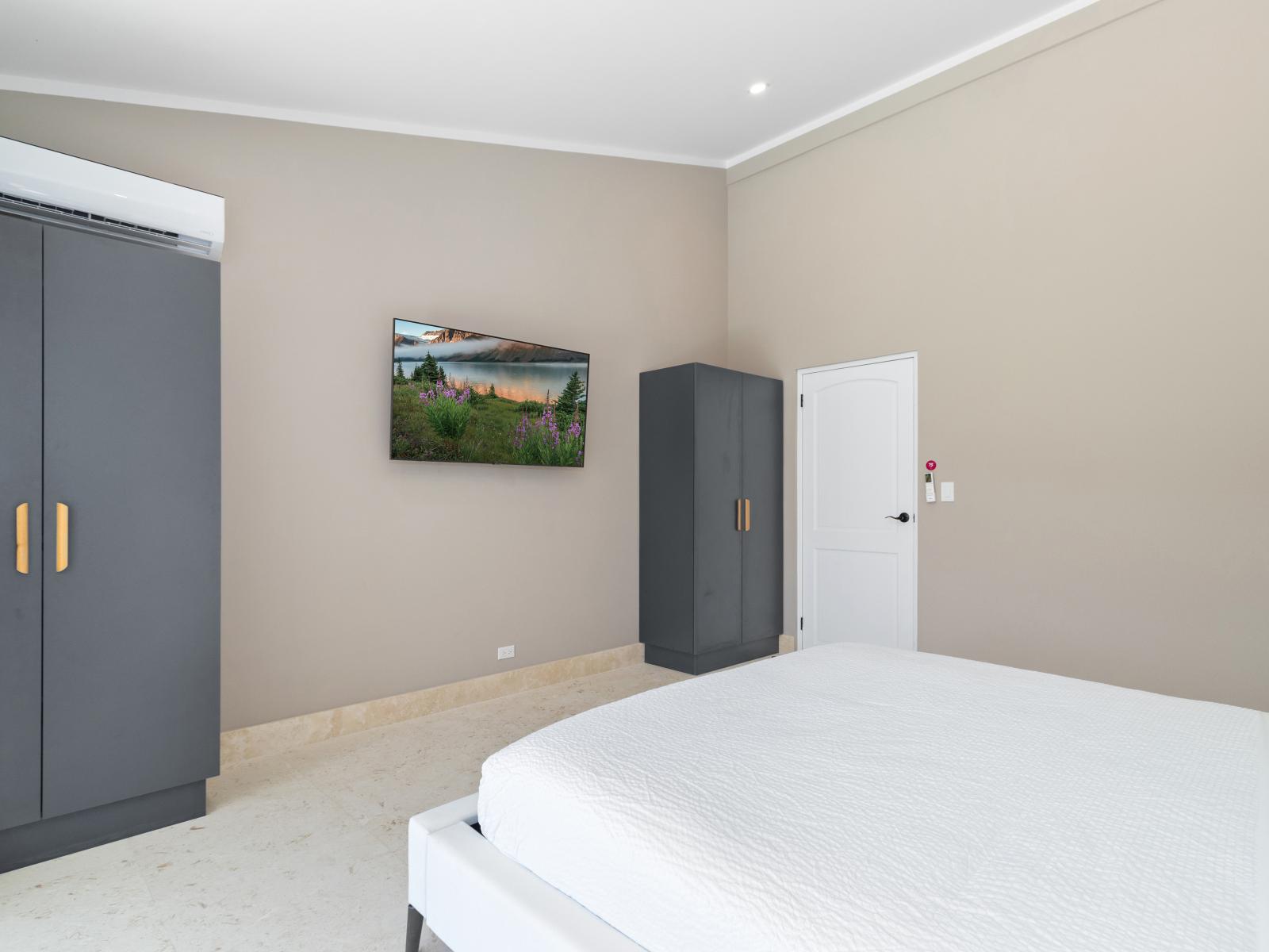 Swish Bedroom of the Villa in Noord Aruba - Minimalist decor, creating a clean and uncluttered sleeping space - Smart use of space with efficient storage solutions - Luxurious bedding for a restful night's sleep - Smart TV and Netflix