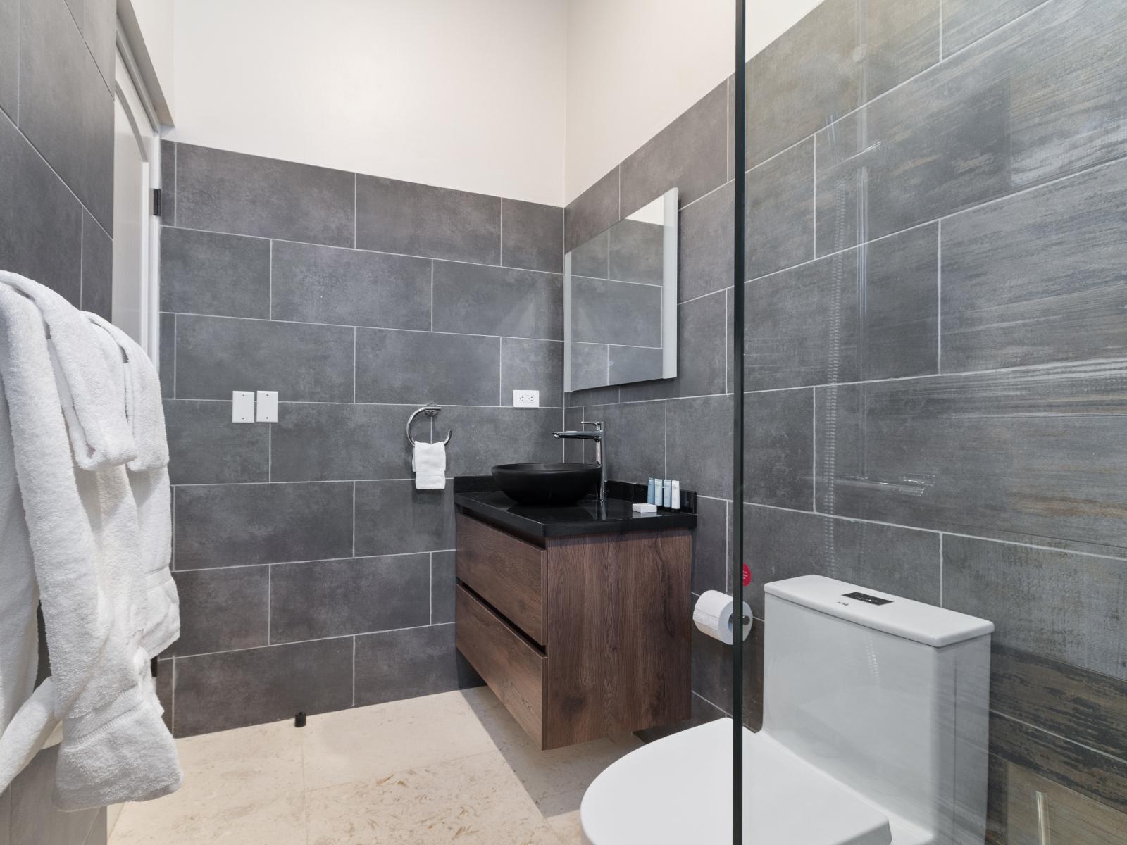 Experience indulgence in Bathroom 5, featuring a spacious walk-in shower designed for your comfort and relaxation.