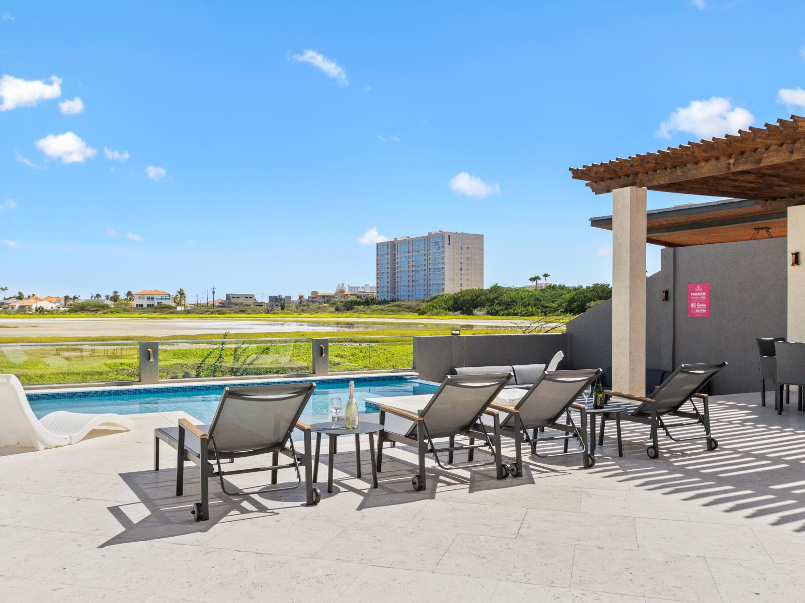 Enjoy sun-soaked bliss with plenty of lounge chairs by the pool, inviting you to bask in the warmth and unwind in ultimate comfort during your stay.