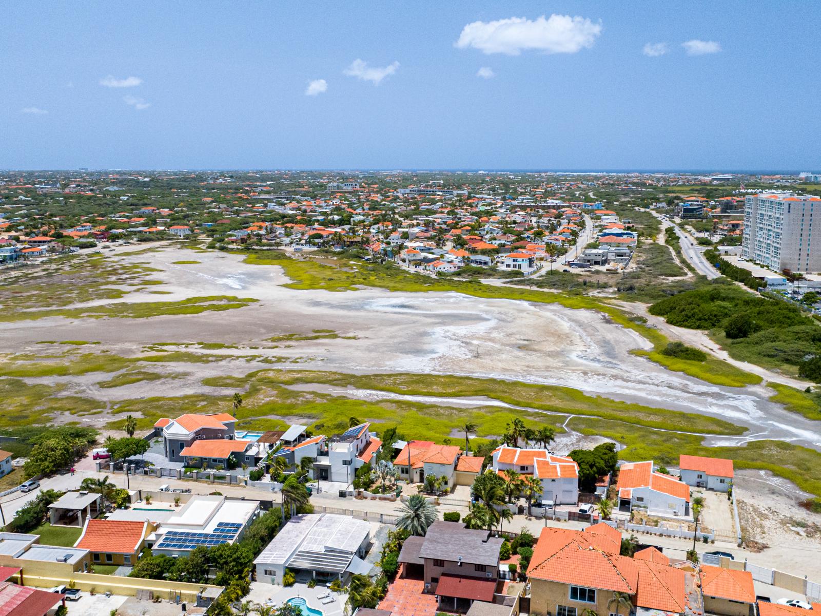 Aerial Panorama: Behold the sweeping panorama of our neighborhood, capturing the majestic Hooiberg, serene Saliña, and the bustling high-rise area, all blending harmoniously to create an enchanting tapestry of our surroundings.