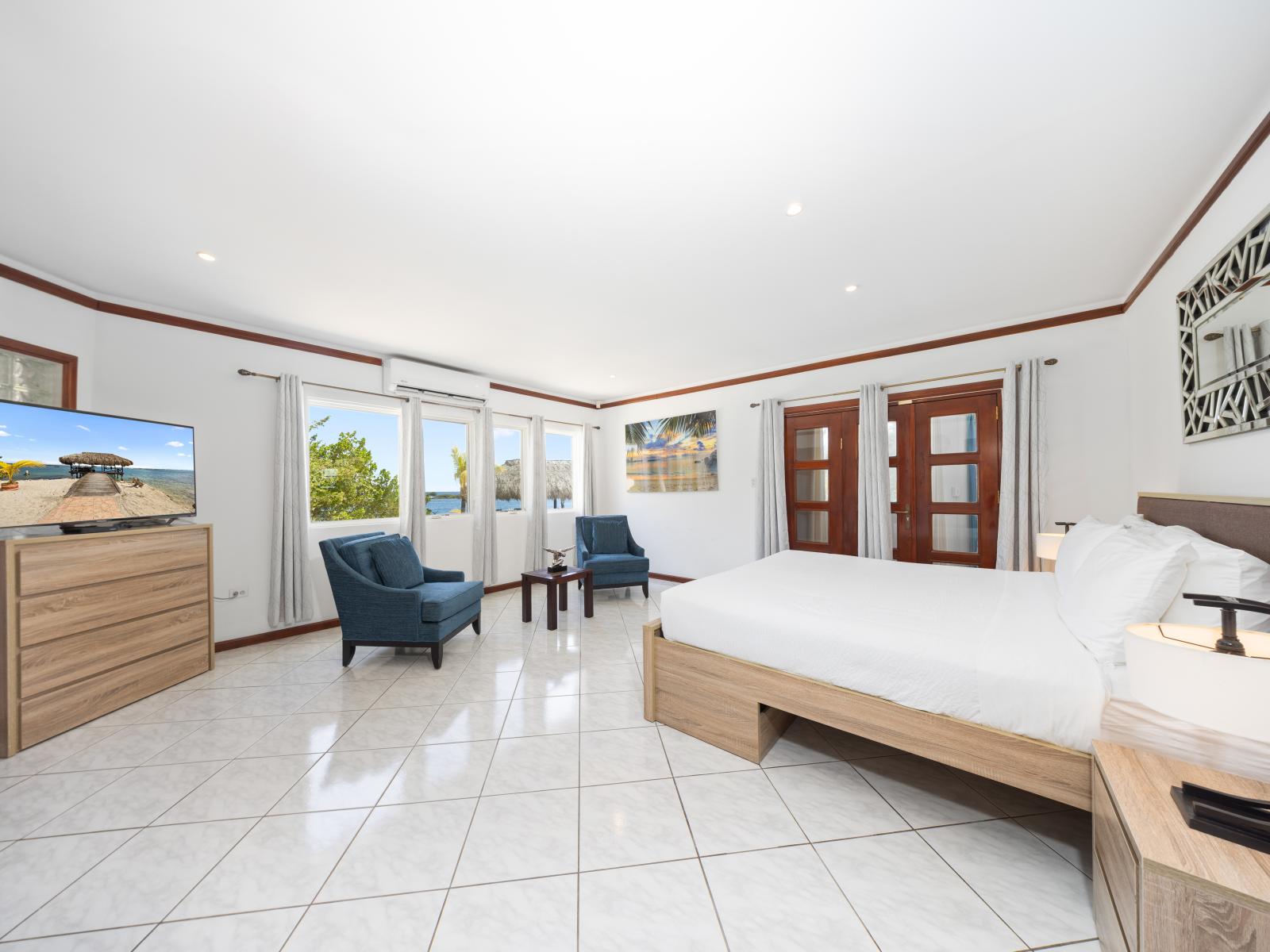 Experience unparalleled comfort in the phenomenal main bedroom. Sink into the king-size bed, where dreams are indulged amidst plush linens. Wake up to spectacular views through the bedside window, offering a glimpse of Aruba's nature