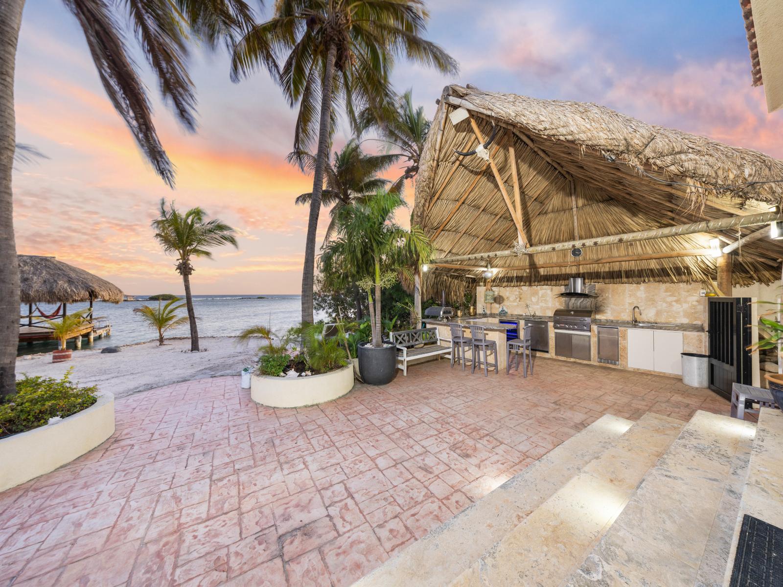 Experience the epitome of outdoor living with our spacious dining table and fully-equipped kitchen, nestled amidst lush surroundings and bathed in the warm glow of Aruba's sunsets.